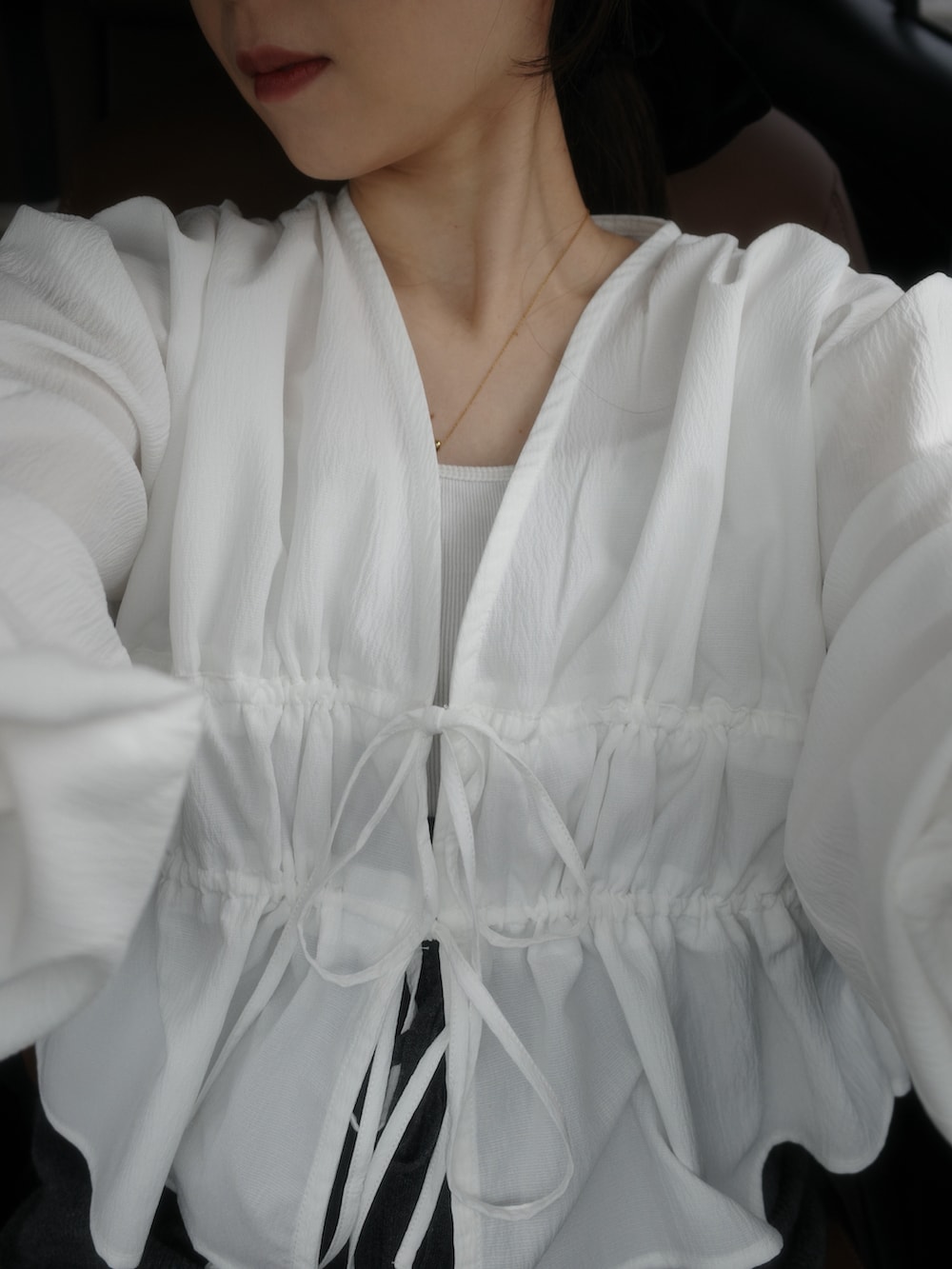 ホワイト系のシャツ/ブラウス、ブラウン系のバッグ、グレー系のパンツを着用したレディースの春コーディネートの2枚目の写真