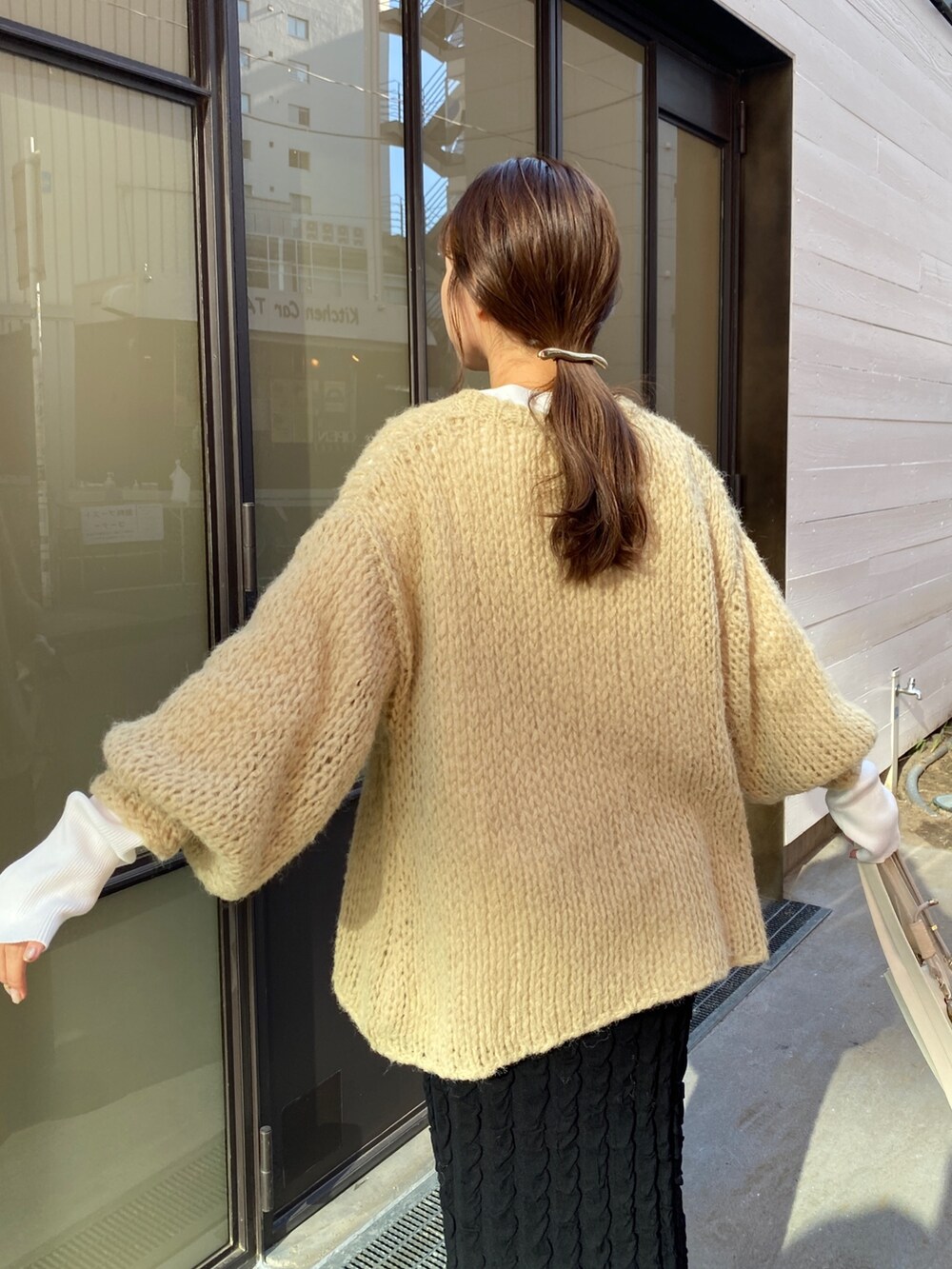 ブラック系のスカート、ベージュ系のニット/セーター、ホワイト系のTシャツ/カットソーを着用したレディースの秋コーディネートの4枚目の写真
