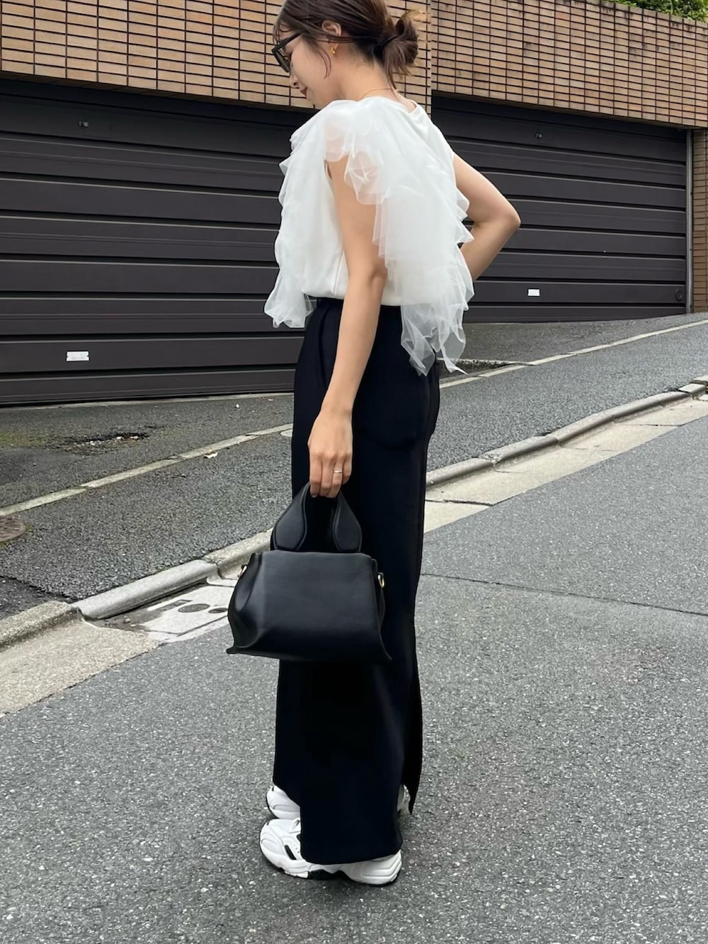 ブラック系のスカート、ホワイト系のTシャツ/カットソー、ブラック系のショルダーバッグを着用したレディースの夏コーディネートの2枚目の写真