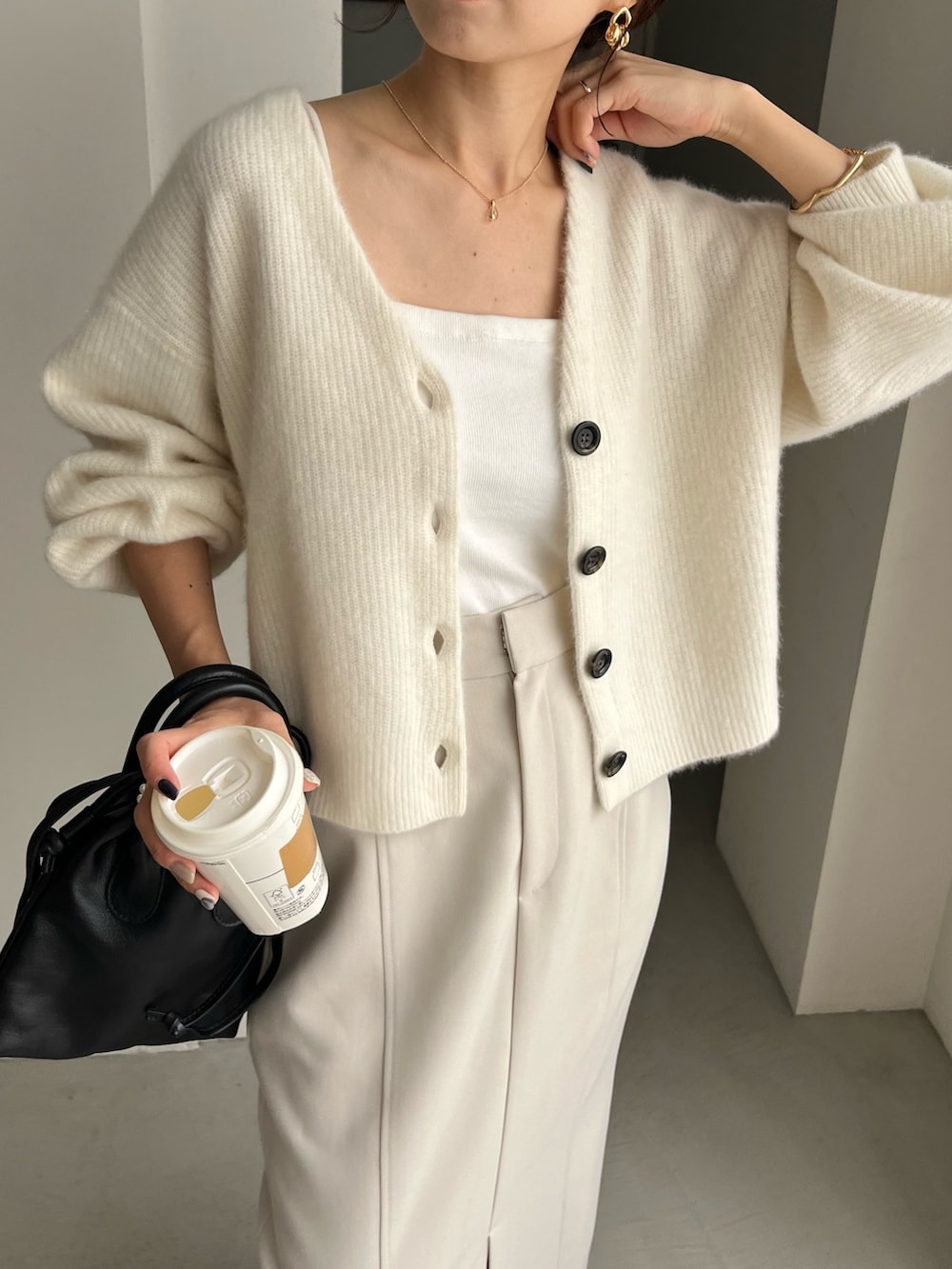 ホワイト系のカーディガン/ボレロ、ブラック系のパンプス、ホワイト系のスカートを着用したレディースの秋コーディネートの4枚目の写真