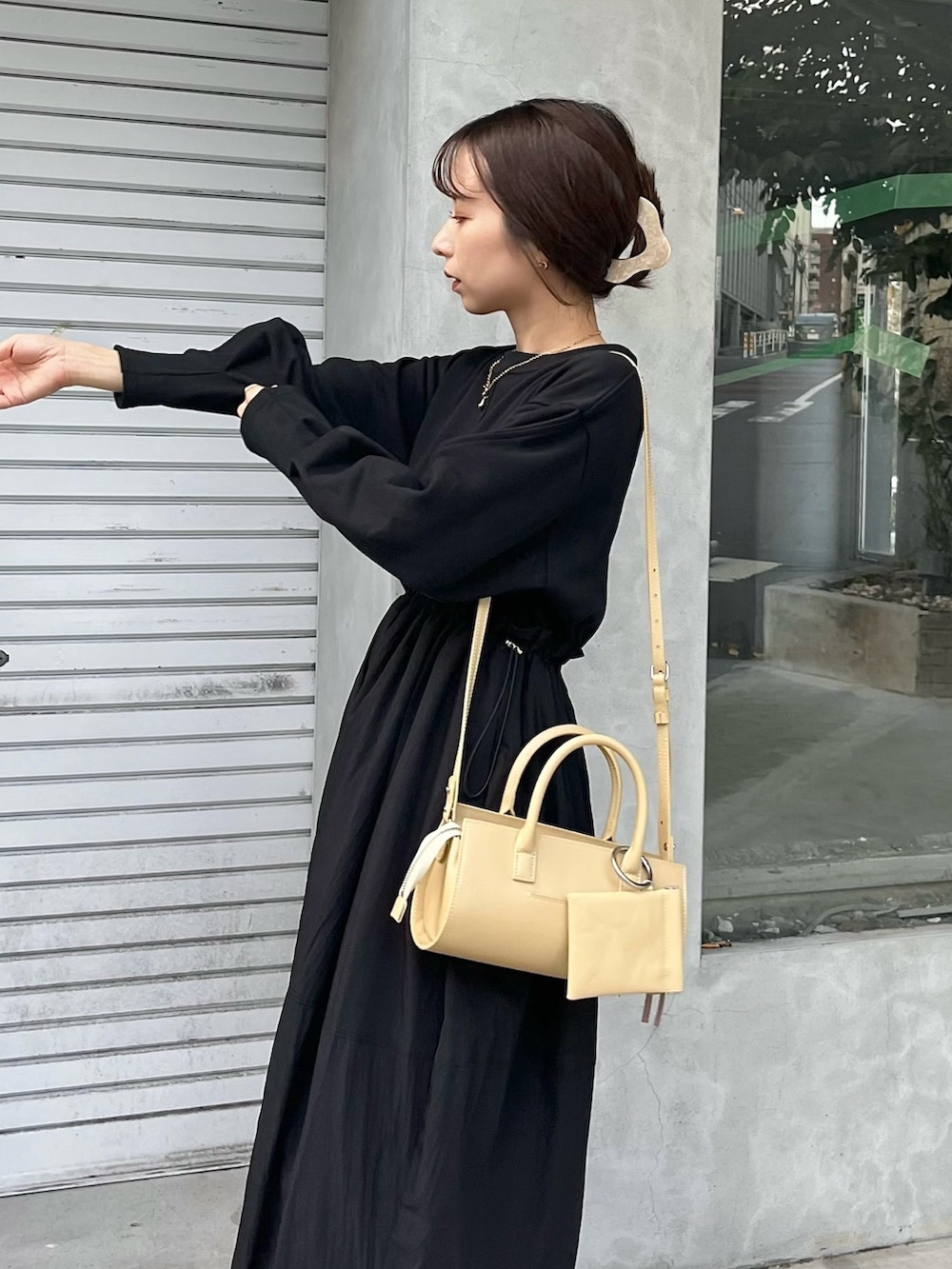 ブラック系のワンピース、ベージュ系のバッグ、ブラック系のブーツを着用したレディースの秋コーディネートの6枚目の写真