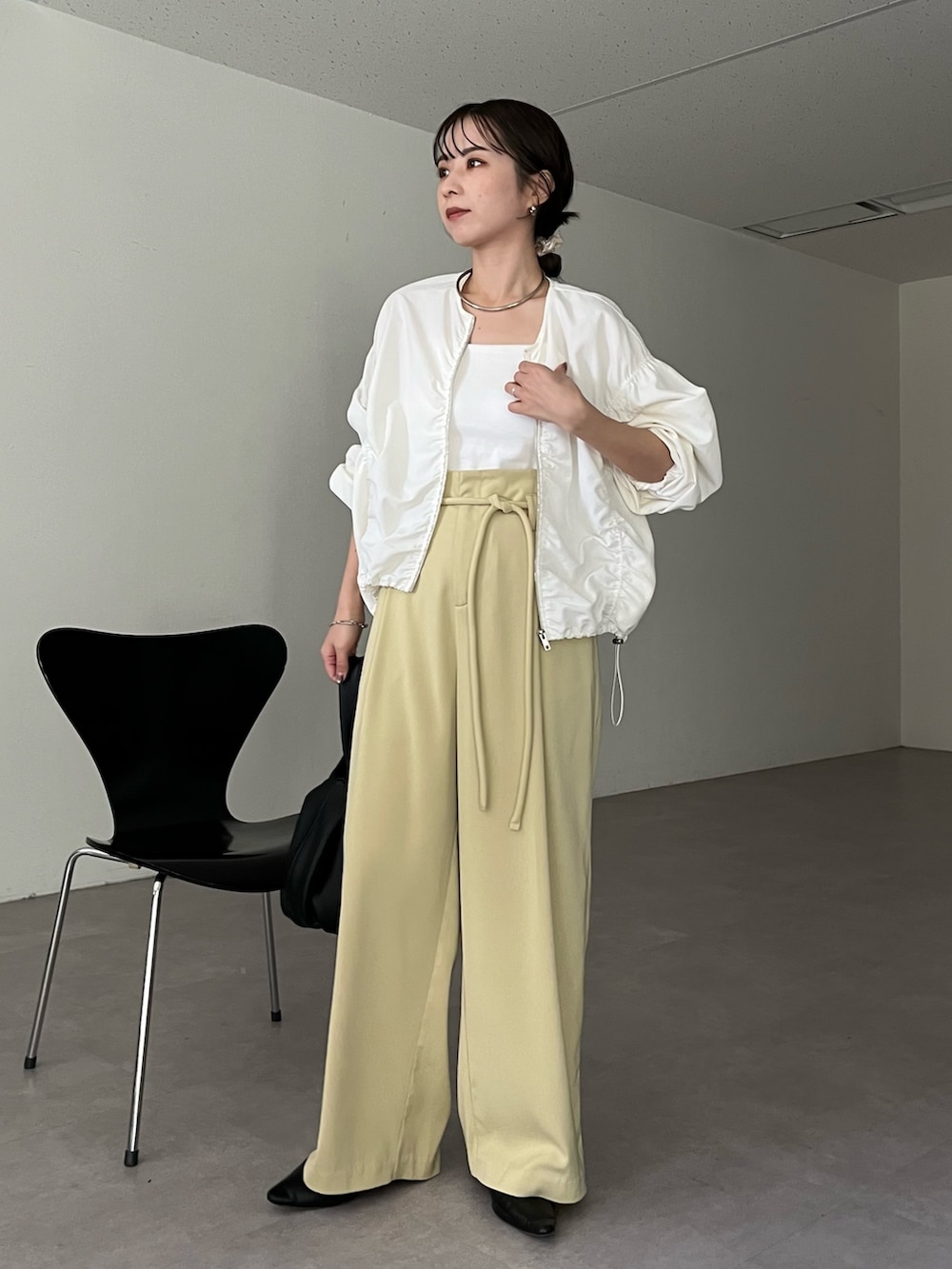 ブラック系のハンドバッグ、グリーン系のその他パンツ、ホワイト系のキャミソールを着用したレディースの春コーディネートの2枚目の写真