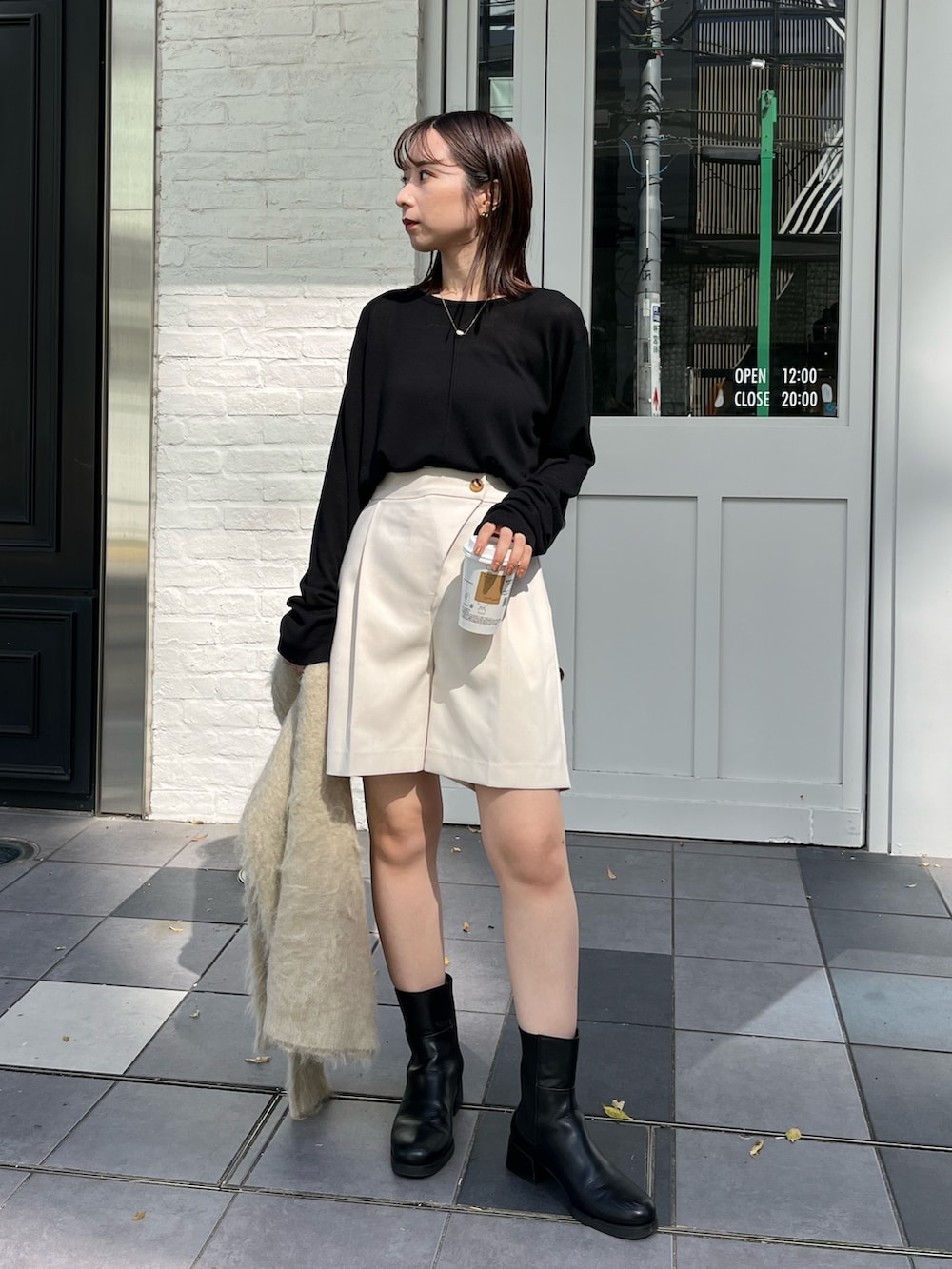 ホワイト系のその他パンツ、ブラック系のニット/セーター、ブラック系のブーツを着用したレディースの秋コーディネートの2枚目の写真