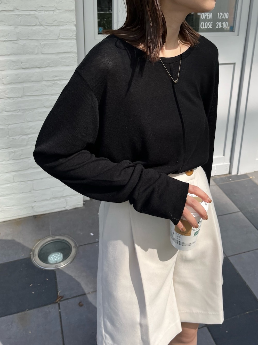 ホワイト系のその他パンツ、ブラック系のニット/セーター、ブラック系のブーツを着用したレディースの秋コーディネートの6枚目の写真