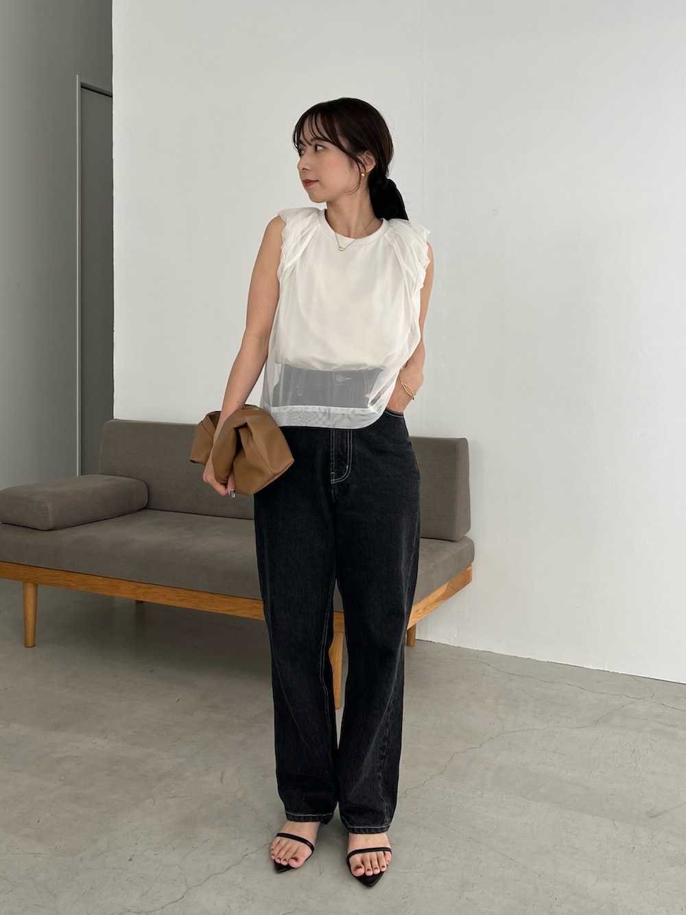 ブラック系のデニムパンツ、イエロー系のショルダーバッグ、ホワイト系のTシャツ/カットソーを着用したレディースの夏コーディネートの5枚目の写真