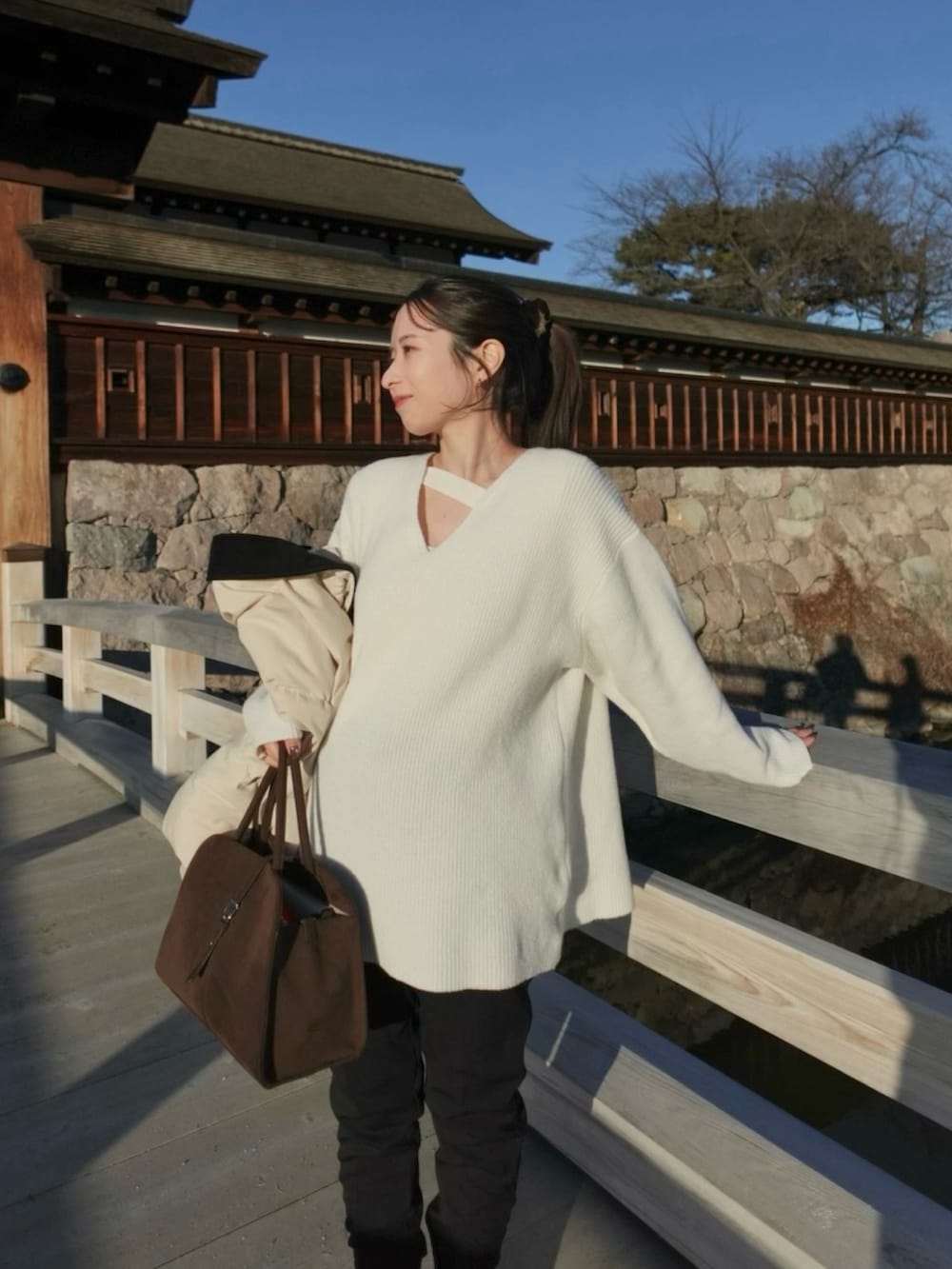 ホワイト系のニット/セーター、ブラック系のブーツ、ブラック系のその他パンツを着用したレディースの冬コーディネートの2枚目の写真