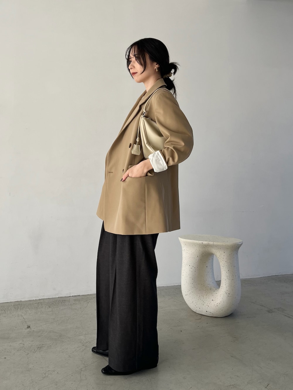 ホワイト系のニット/セーター、ベージュ系のテーラードジャケット、ブラック系のその他パンツを着用したレディースの冬コーディネートの3枚目の写真