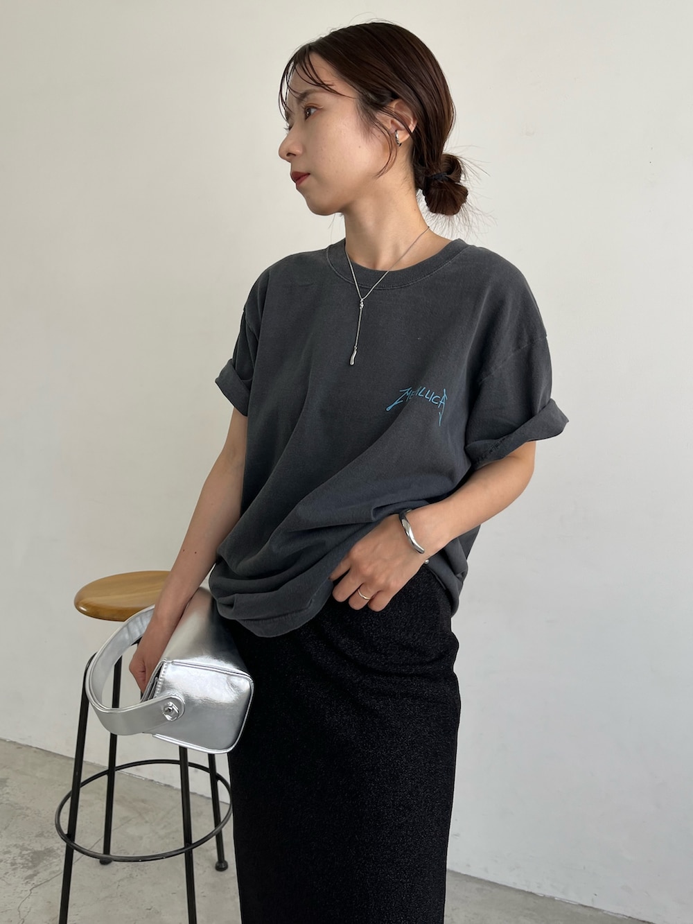 ブラック系のスカート、シルバー系のショルダーバッグ、ブラック系のサンダルを着用したレディースの夏コーディネートの4枚目の写真