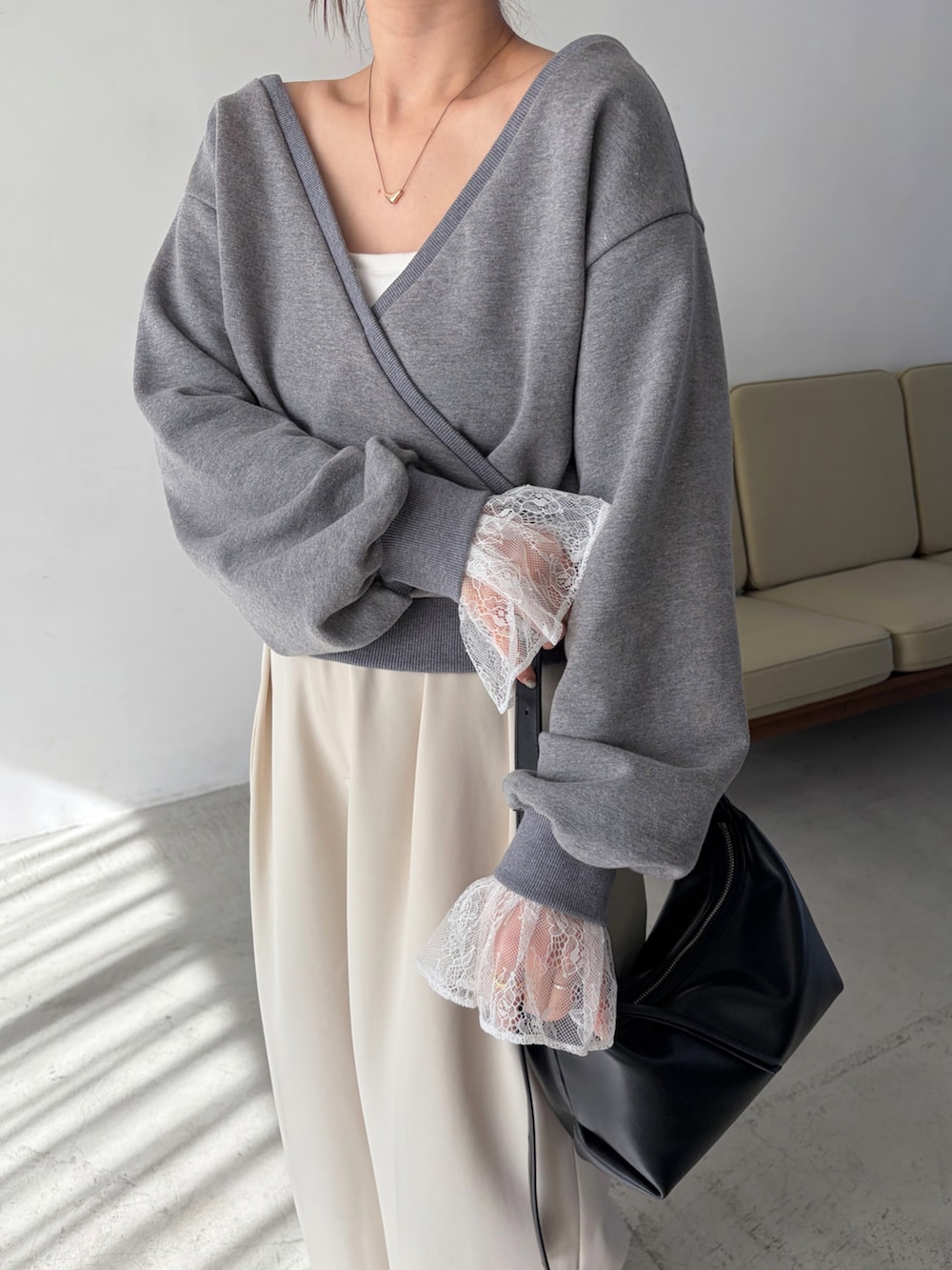 グレー系のTシャツ/カットソー、ホワイト系のその他パンツ、ブラック系のショルダーバッグを着用したレディースの冬コーディネートの4枚目の写真