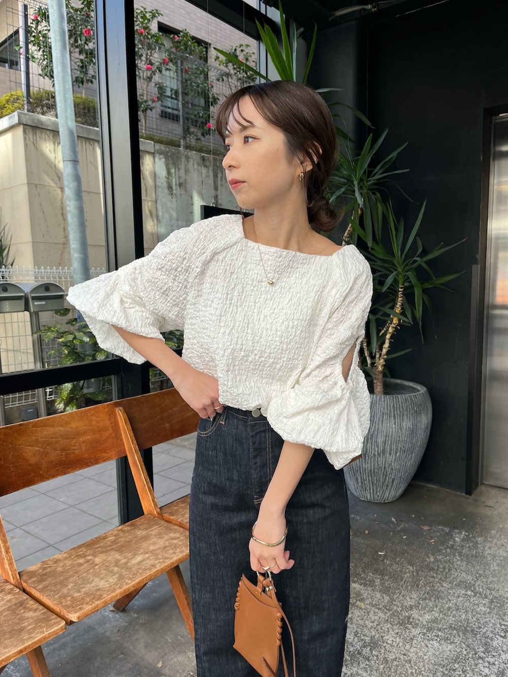 ブラック系のサンダル、ホワイト系のシャツ/ブラウス、ブルー系のデニムパンツを着用したレディースの春コーディネートの6枚目の写真