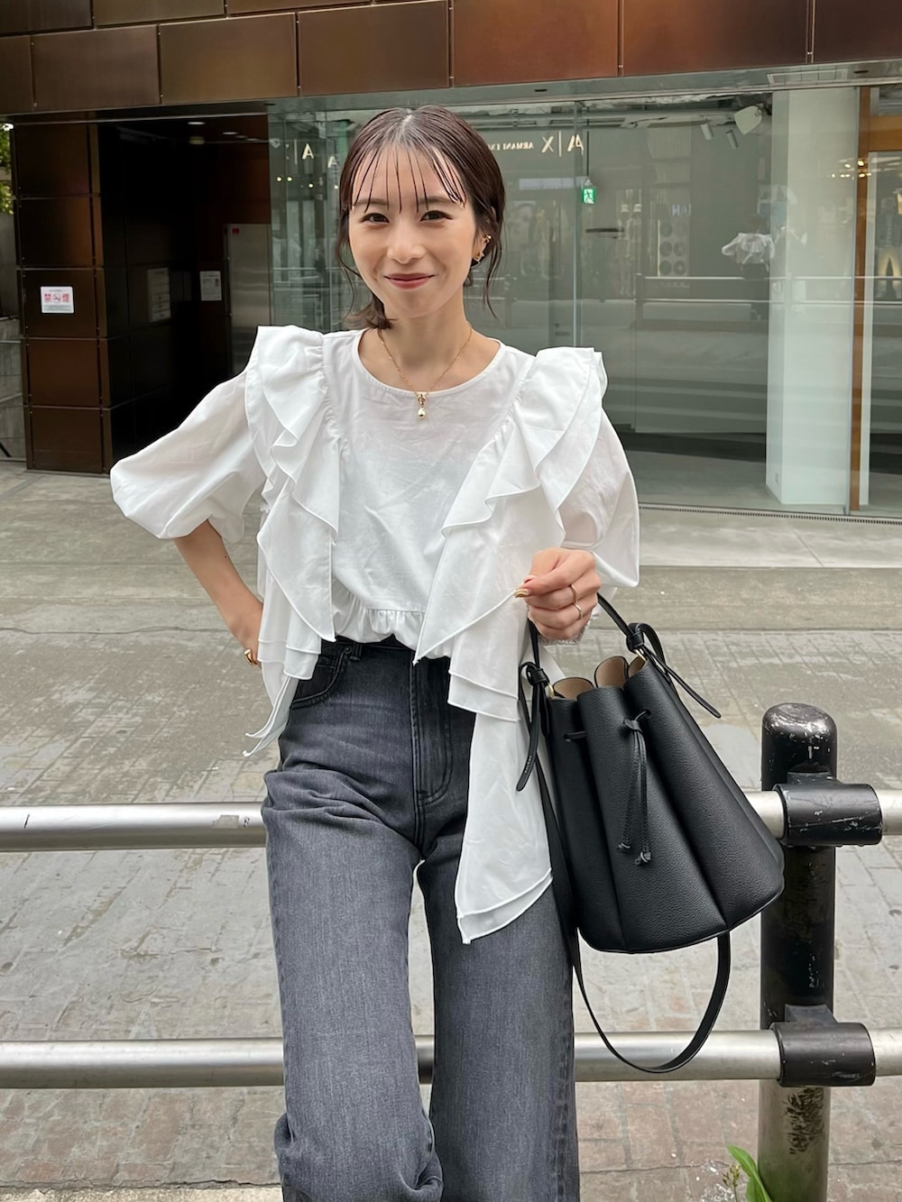 ホワイト系のシャツ/ブラウス、ブラック系のバッグ、ブラック系のサンダルを着用したレディースの春コーディネートの6枚目の写真