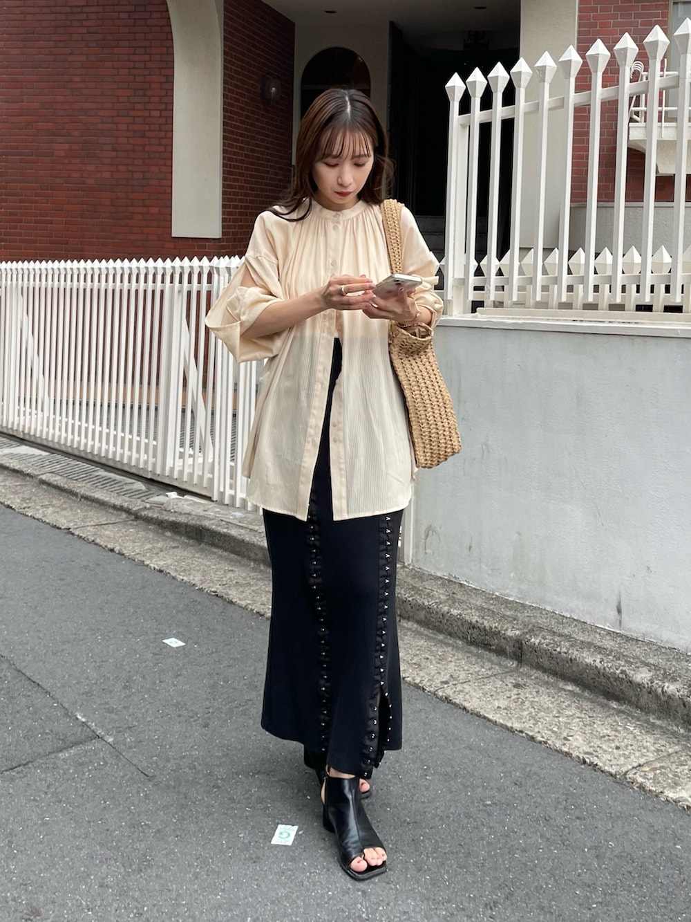 ベージュ系のシャツ/ブラウス、ブラック系のスカート、ブラック系のサンダルを着用したレディースの夏コーディネートの3枚目の写真