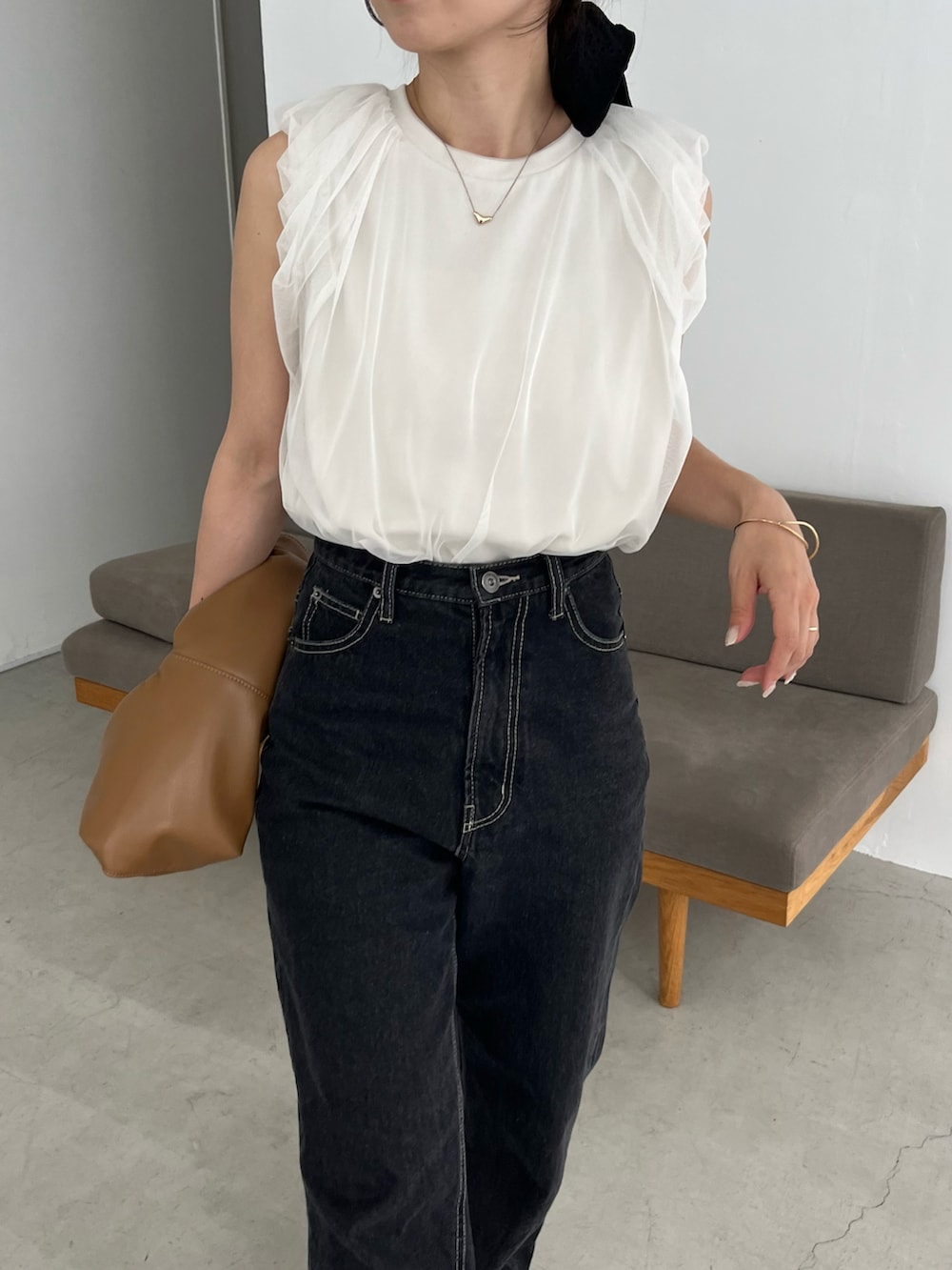ブラック系のデニムパンツ、イエロー系のショルダーバッグ、ホワイト系のTシャツ/カットソーを着用したレディースの夏コーディネートの3枚目の写真