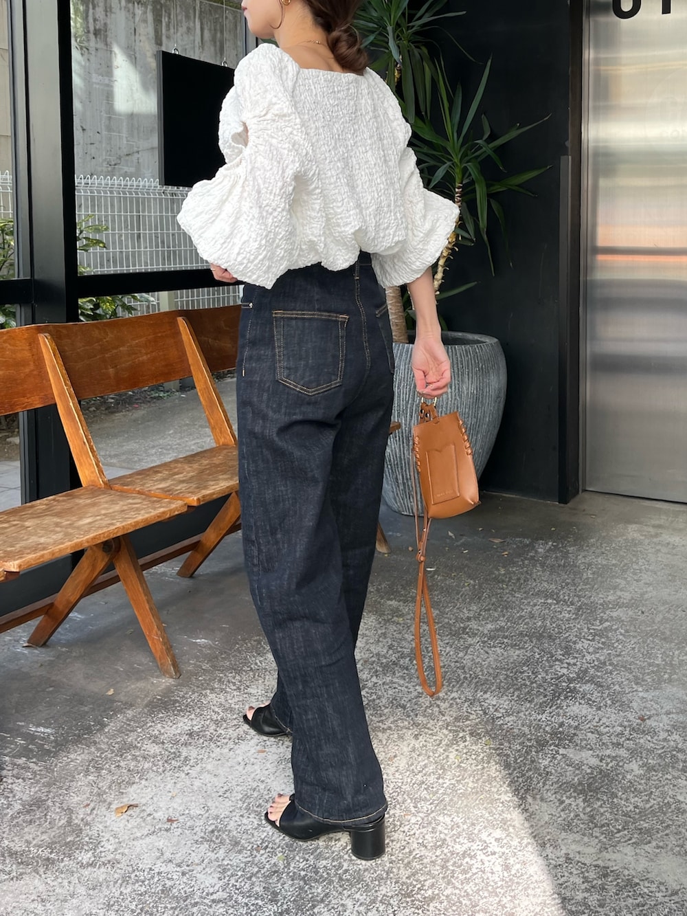 ブラック系のサンダル、ホワイト系のシャツ/ブラウス、ブルー系のデニムパンツを着用したレディースの春コーディネートの3枚目の写真