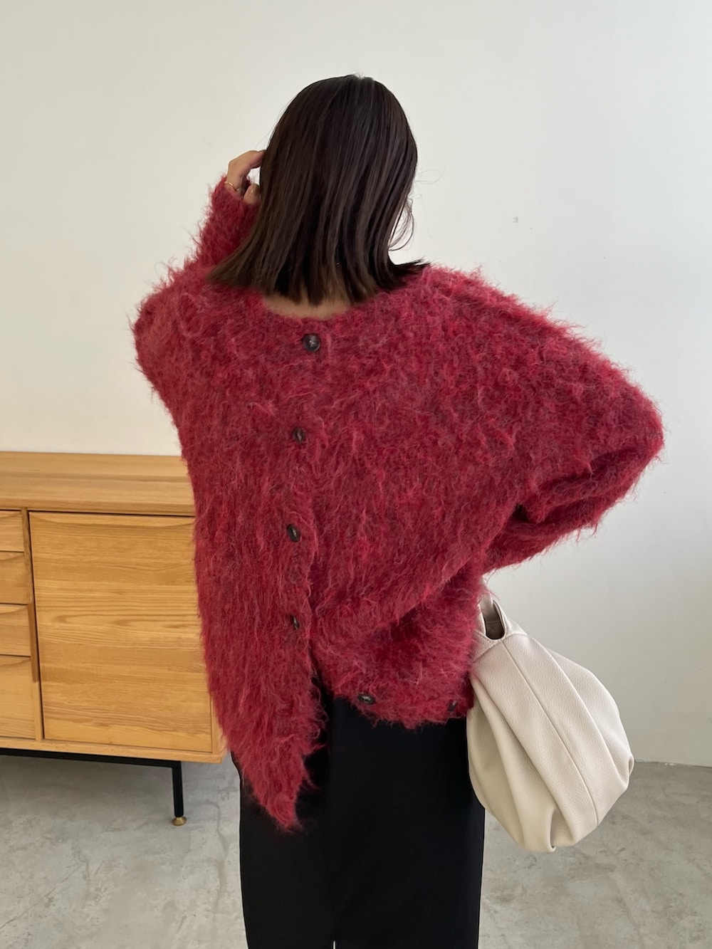 レッド系のカーディガン/ボレロ、ブラック系のワンピース、ホワイト系のハンドバッグを着用したレディースの冬コーディネートの7枚目の写真