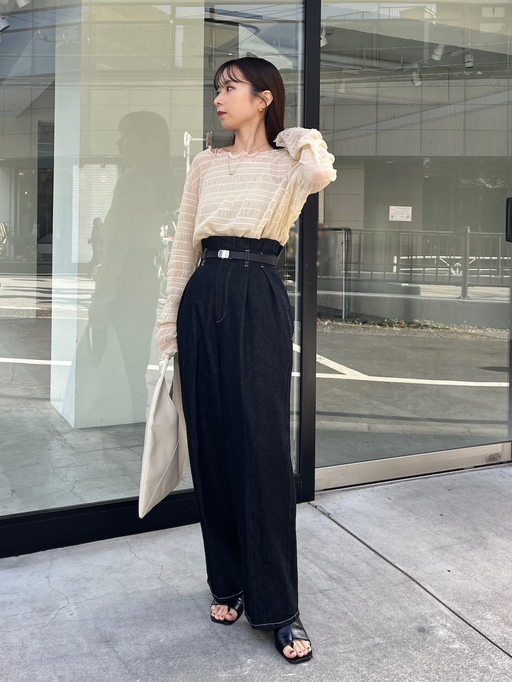 ブラック系のその他パンツ、ベージュ系のTシャツ/カットソー、ブラック系のサンダルを着用したレディースの冬コーディネートの3枚目の写真