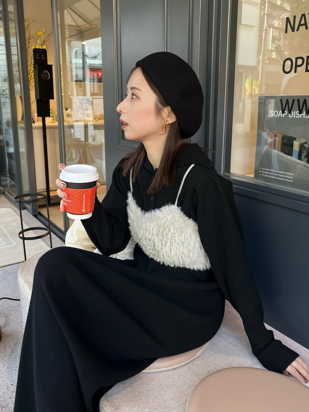 ブラック系のワンピース、ホワイト系のダウンジャケット/コート、グリーン系のトップスを着用したレディースの冬コーディネートの2枚目の写真