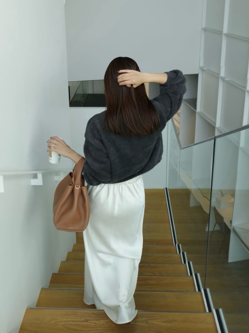 ホワイト系のスカート、ブラウン系のバッグ、グレー系のカーディガン/ボレロを着用したレディースの秋コーディネートの4枚目の写真