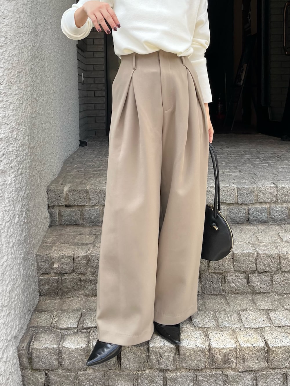 ベージュ系のその他パンツ、ホワイト系のニット/セーター、ブラック系のパンプスを着用したレディースの秋コーディネートの6枚目の写真