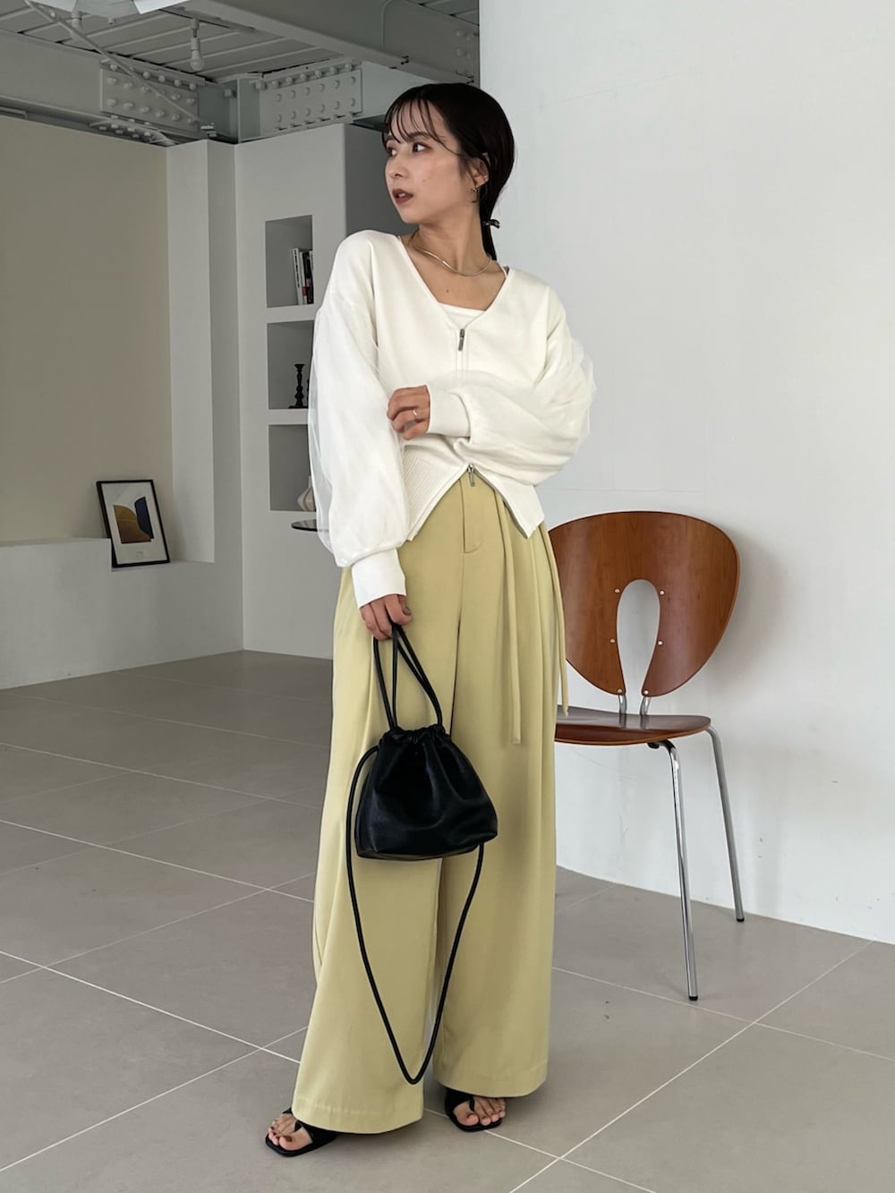 ホワイト系のカーディガン/ボレロ、グリーン系のその他パンツ、ブラック系のブーツを着用したレディースの冬コーディネートの2枚目の写真