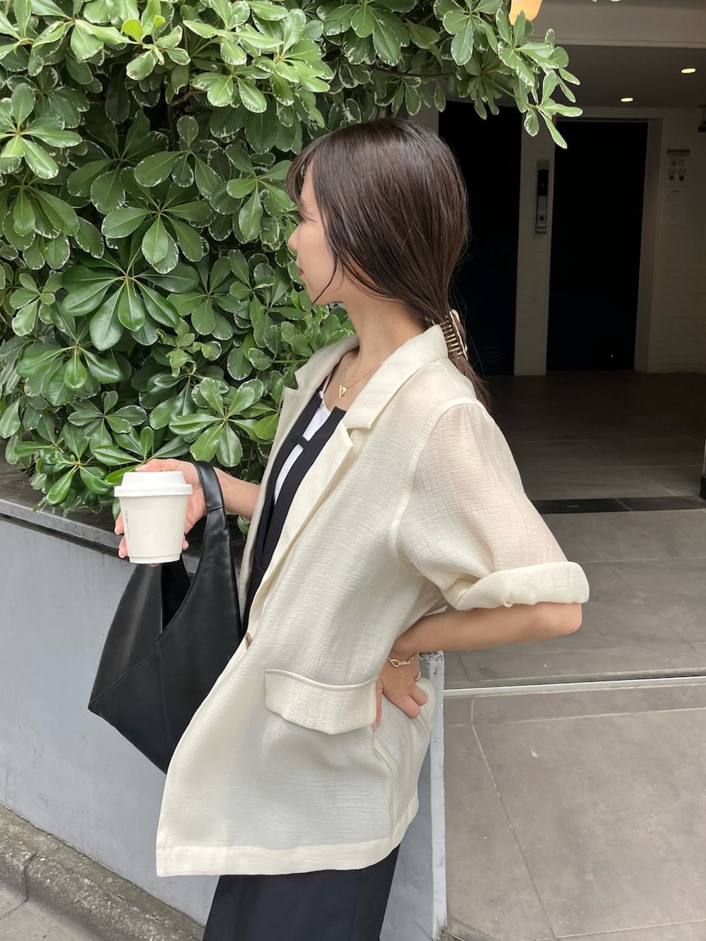 ブラック系のワンピース、ブラック系のその他シューズ、ホワイト系のテーラードジャケットを着用したレディースの春コーディネートの2枚目の写真