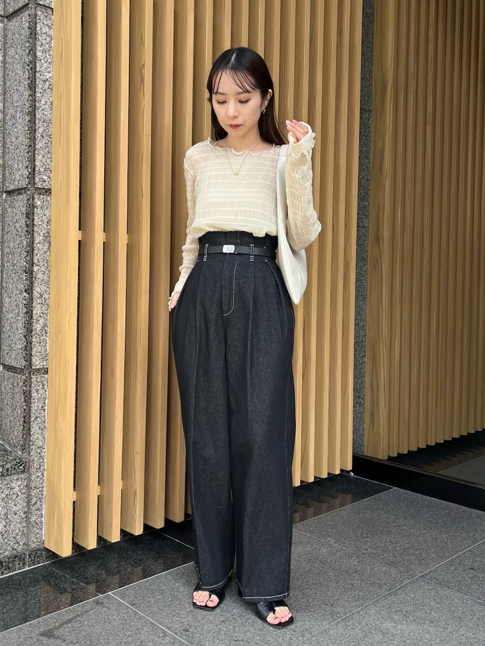 ブラック系のその他パンツ、ベージュ系のTシャツ/カットソー、ブラック系のサンダルを着用したレディースの冬コーディネートの4枚目の写真