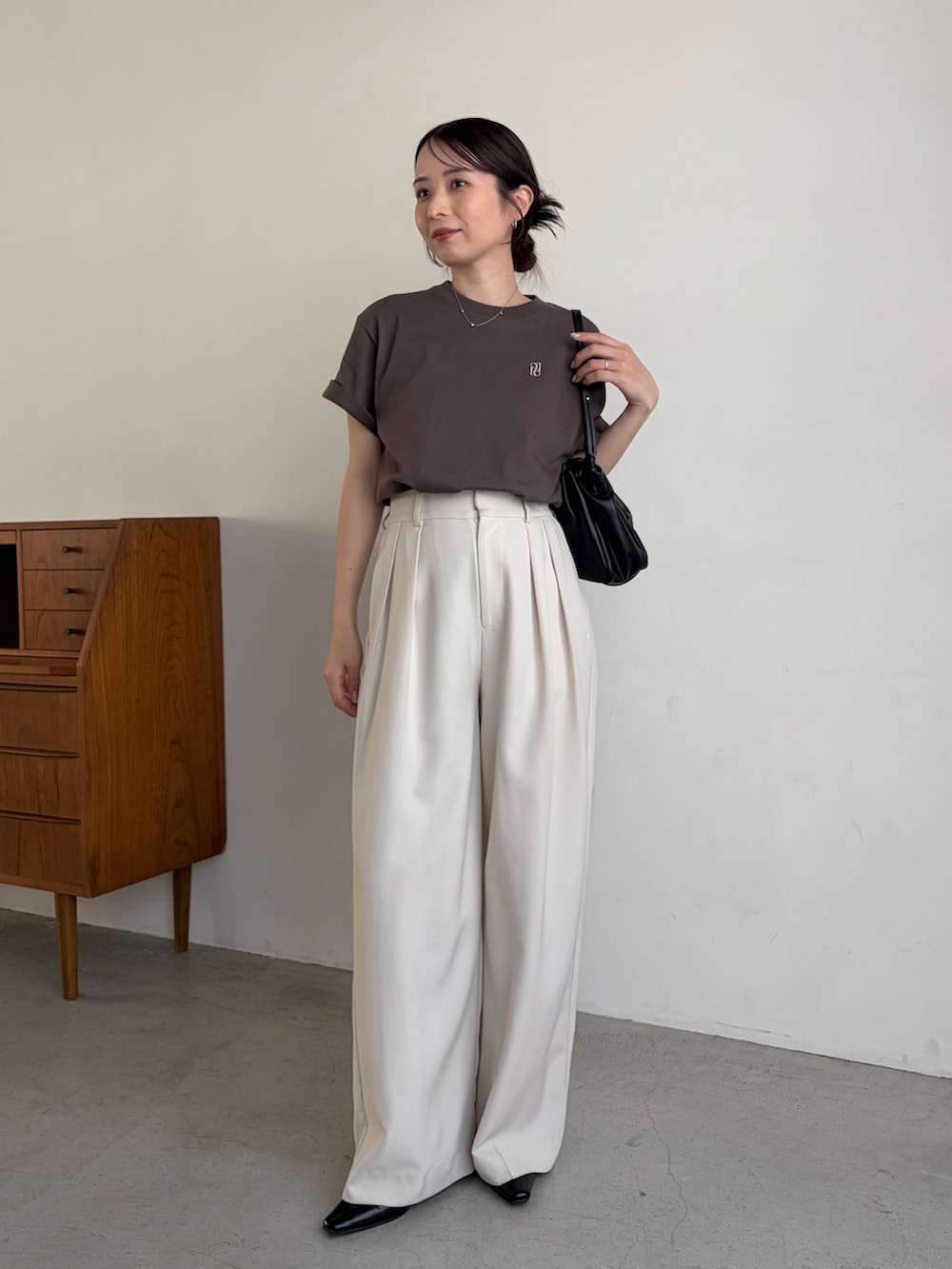 ブラウン系のTシャツ/カットソー、ホワイト系のその他パンツ、ブラック系のショルダーバッグを着用したレディースの春コーディネートの2枚目の写真