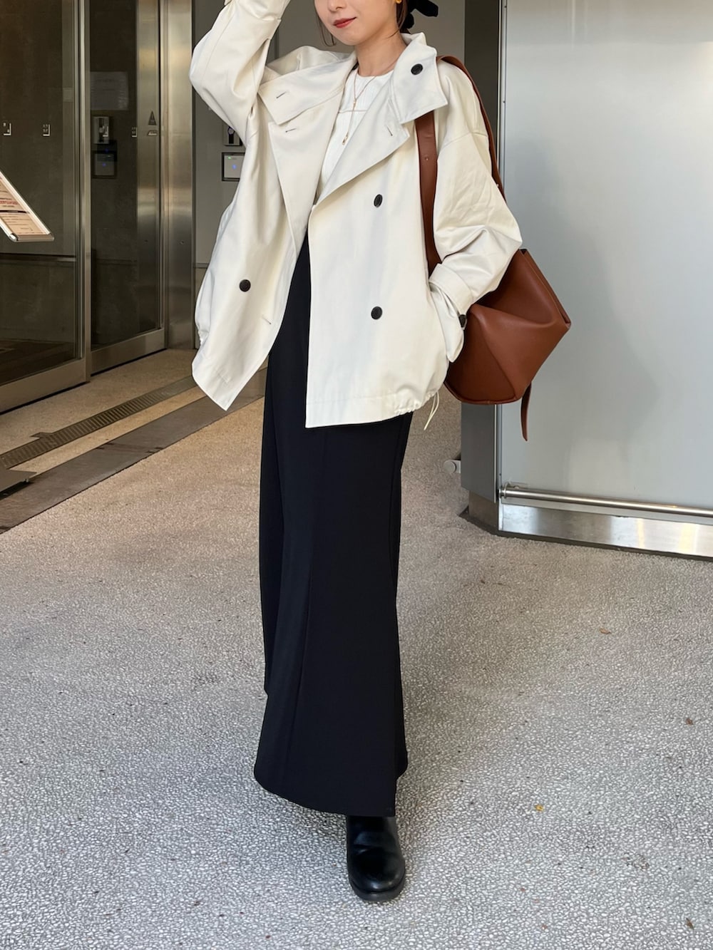 ホワイト系のその他アウター、ブラック系のスカート、イエロー系のショルダーバッグを着用したレディースの冬コーディネートの6枚目の写真