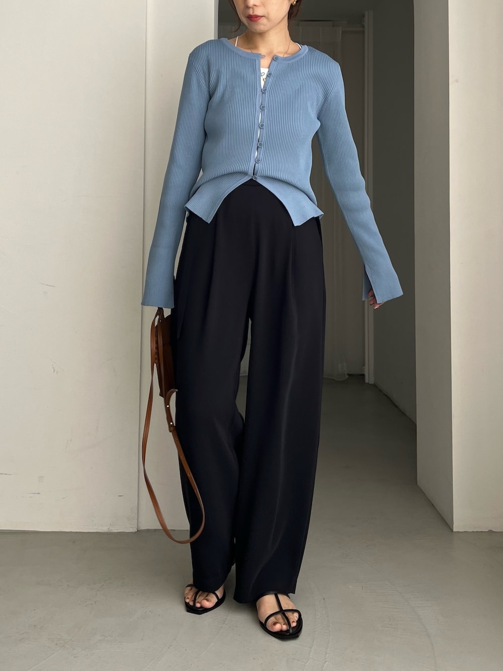 ブラック系のその他パンツ、ブルー系のカーディガン/ボレロ、ブラウン系のトートバッグを着用したレディースの冬コーディネートの2枚目の写真