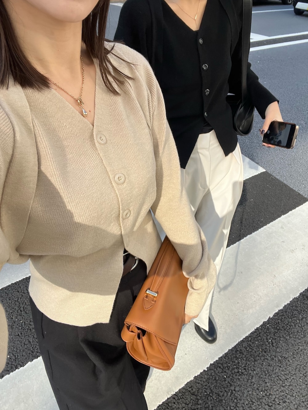 ブラック系のスラックス、ベージュ系のショルダーバッグ、ベージュ系のカーディガン/ボレロを着用したレディースの冬コーディネートの4枚目の写真