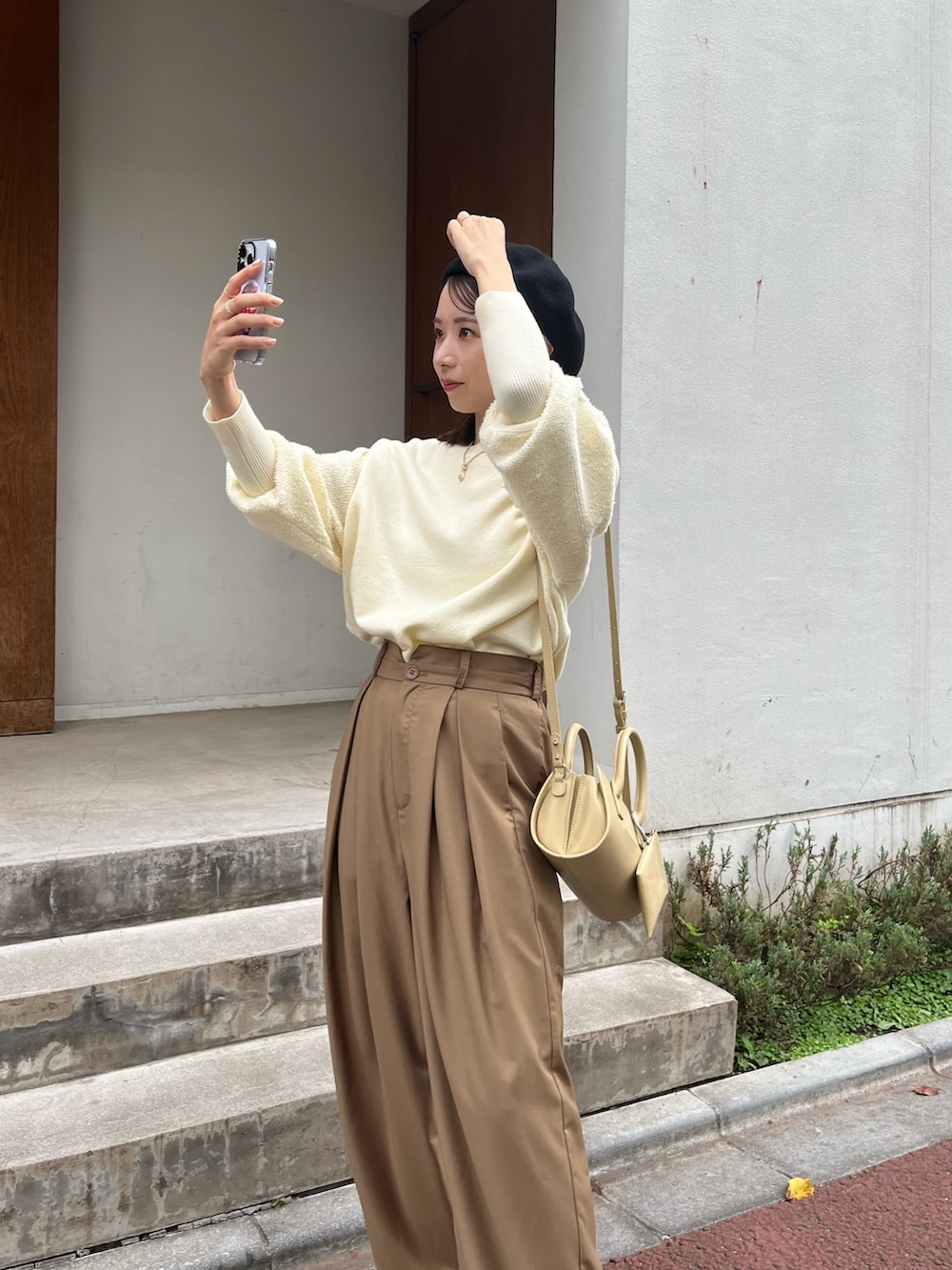 ベージュ系のバッグ、ホワイト系のニット/セーター、ブラウン系のその他パンツを着用したレディースの秋コーディネートの3枚目の写真