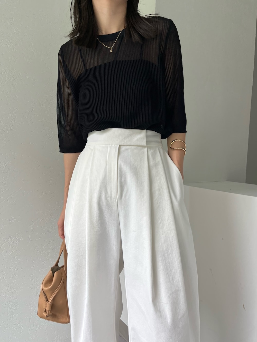 ホワイト系のその他パンツ、ブラック系のニット/セーター、ブラック系のタンクトップを着用したレディースの夏コーディネートの4枚目の写真