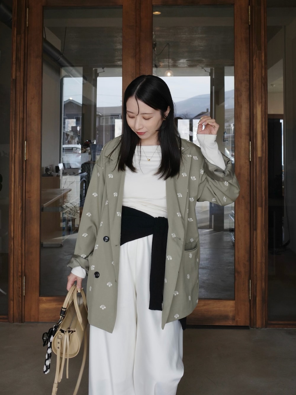 グリーン系のテーラードジャケット、ホワイト系のその他パンツ、ベージュ系のバッグを着用したレディースの春コーディネートの4枚目の写真