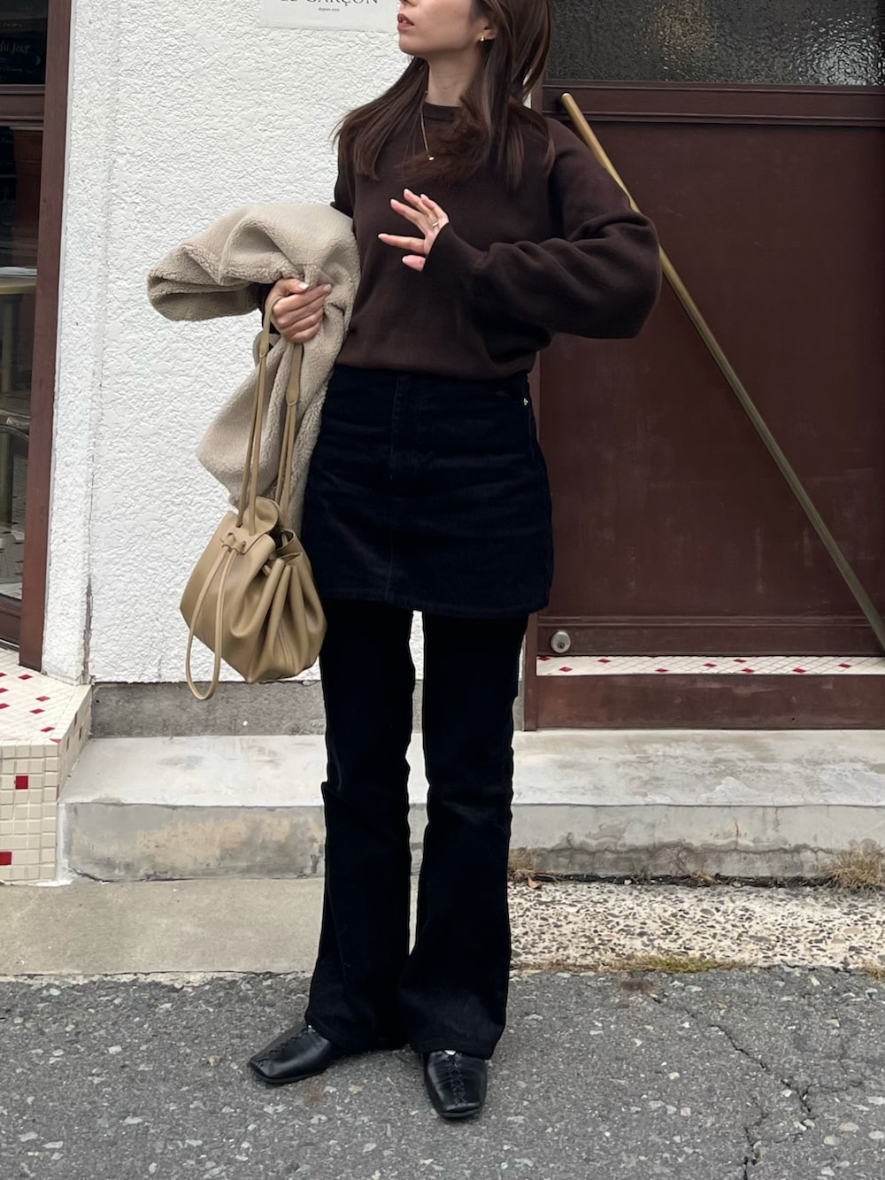 ベージュ系のその他アウター、ベージュ系のショルダーバッグ、ブラック系のその他パンツを着用したレディースの冬コーディネートの2枚目の写真