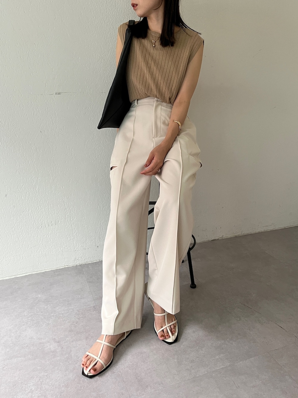 ホワイト系のその他パンツ、ベージュ系のニット/セーター、ブラック系のバッグを着用したレディースの夏コーディネートの5枚目の写真