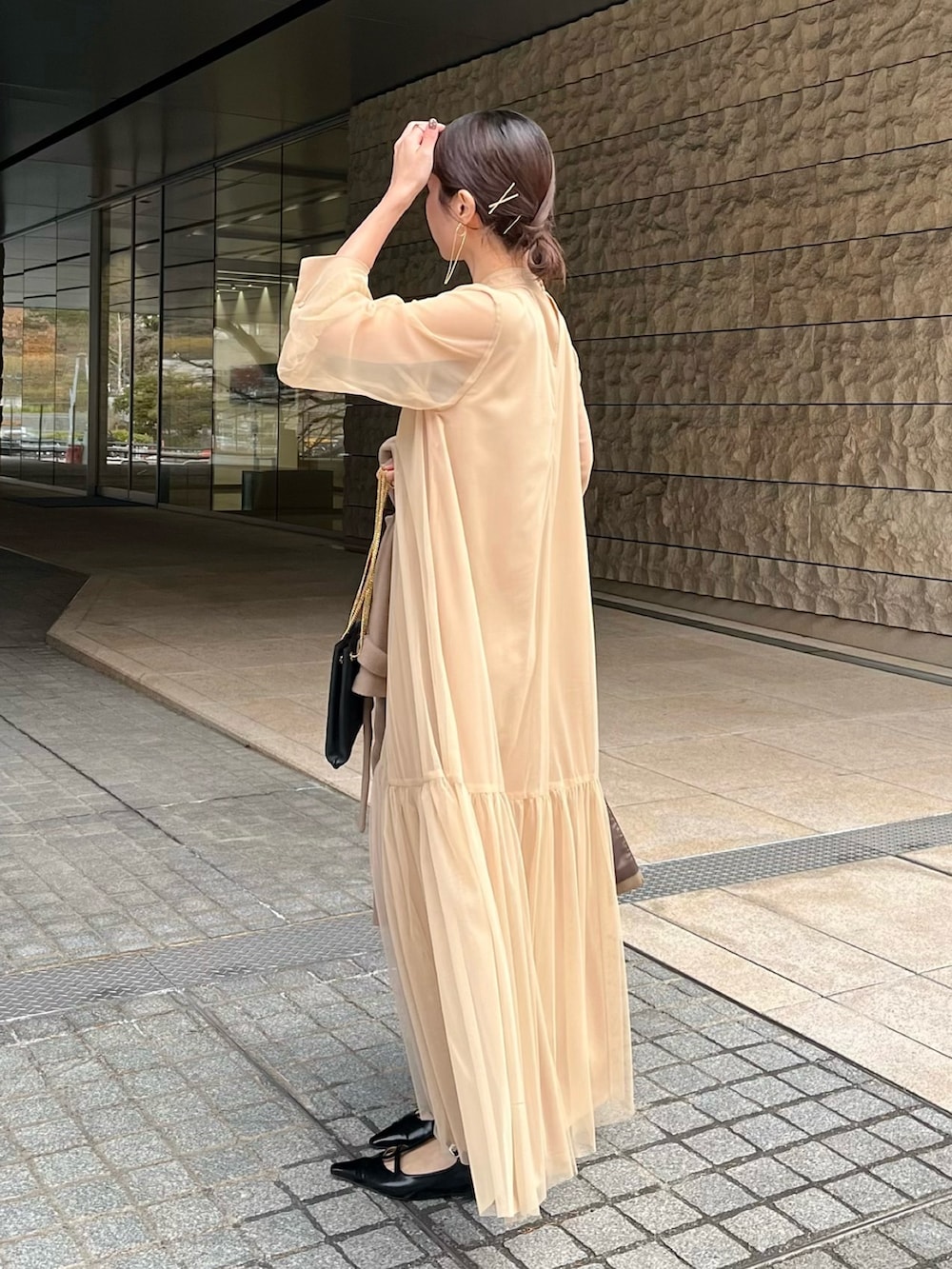 ベージュ系のワンピース、ブラック系のショルダーバッグ、ブラック系のパンプスを着用したレディースの冬コーディネートの3枚目の写真