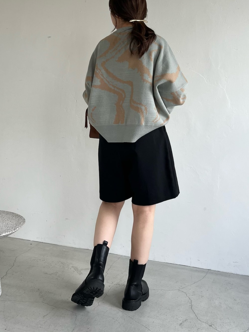 ブラック系のその他パンツ、ブラウン系のトートバッグ、グリーン系のニット/セーターを着用したレディースの秋コーディネートの5枚目の写真