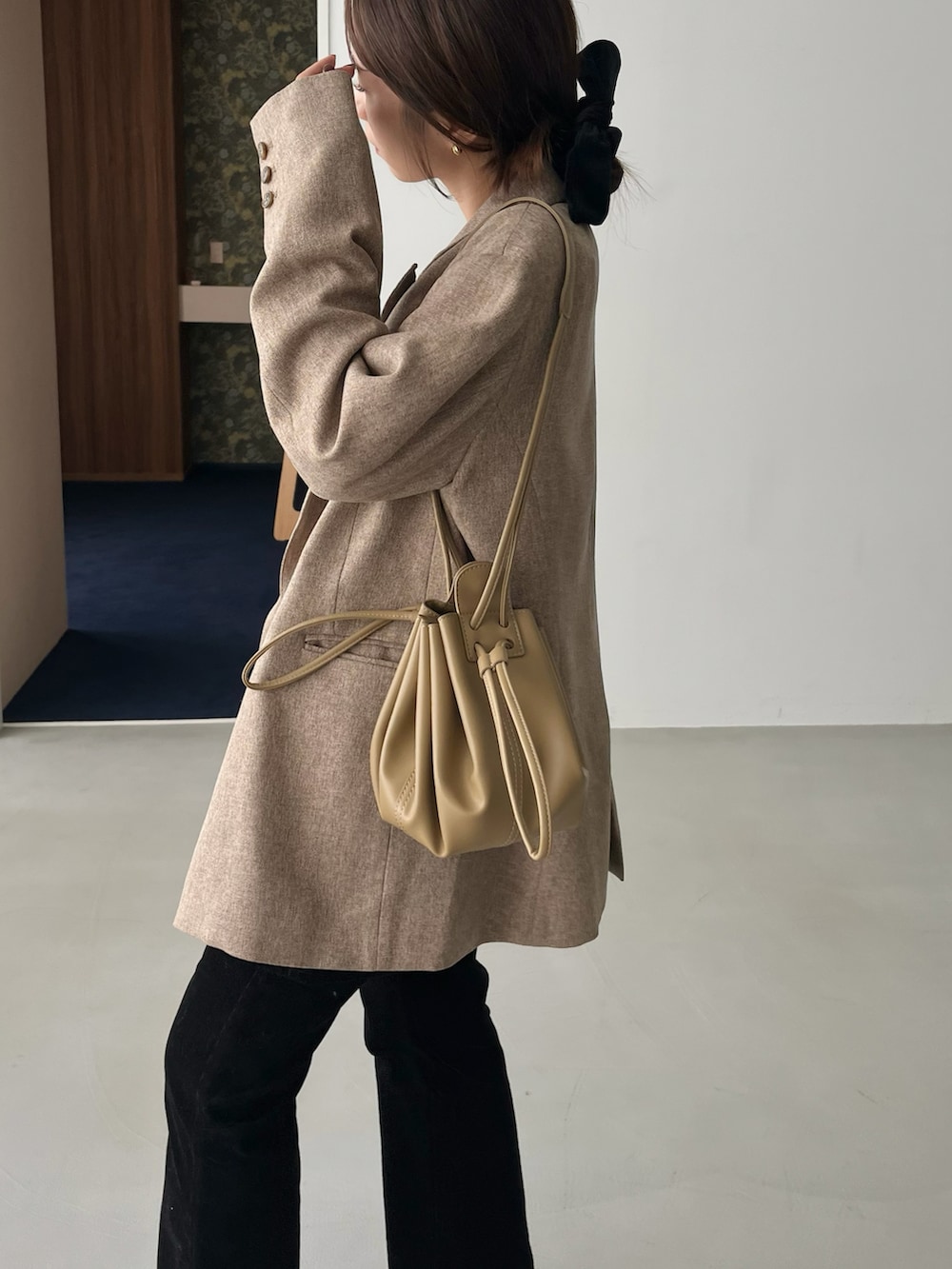 ホワイト系のニット/セーター、ベージュ系のテーラードジャケット、ブラック系のその他パンツを着用したレディースの秋コーディネートの5枚目の写真