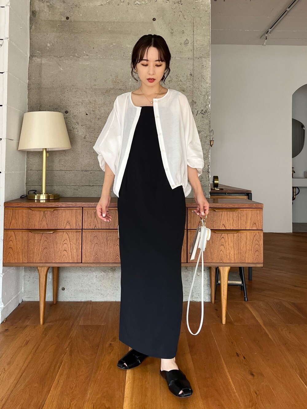 ブラック系のワンピース、ホワイト系のブルゾン、ブラック系のトートバッグを着用したレディースの夏コーディネートの3枚目の写真