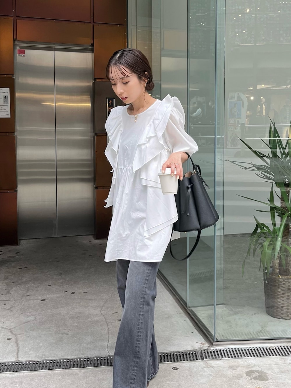 ホワイト系のシャツ/ブラウス、ブラック系のバッグ、ブラック系のサンダルを着用したレディースの春コーディネートの4枚目の写真