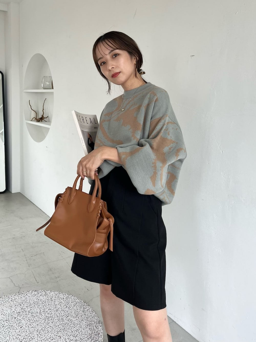 ブラック系のその他パンツ、ブラウン系のトートバッグ、グリーン系のニット/セーターを着用したレディースの秋コーディネートの3枚目の写真