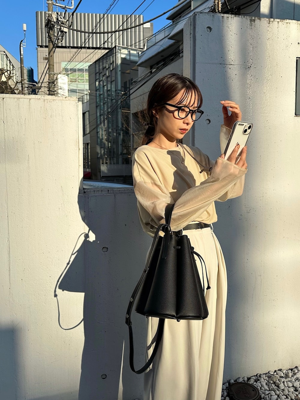 ホワイト系のその他パンツ、ベージュ系のTシャツ/カットソー、ブラック系のバッグを着用したレディースの冬コーディネートの3枚目の写真