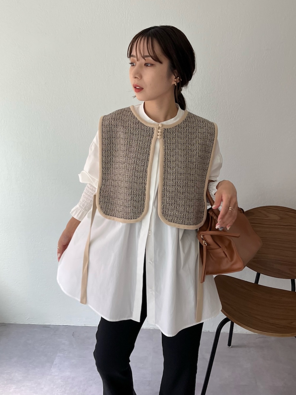 ベージュ系のニット/セーター、ホワイト系のシャツ/ブラウス、ブラウン系のトートバッグを着用したレディースの夏コーディネートの3枚目の写真