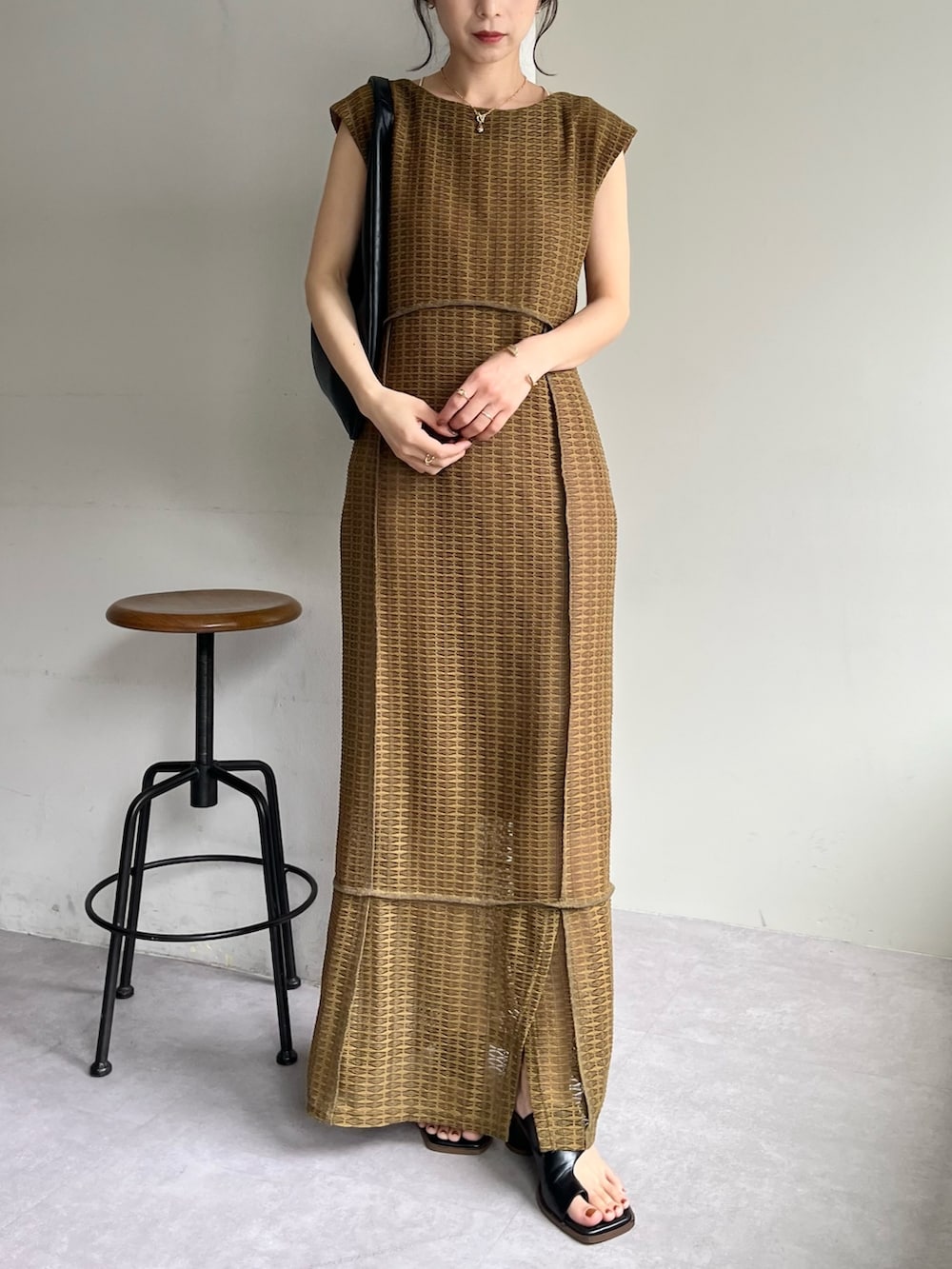 ベージュ系のワンピース、ブラック系のバッグ、ブラック系のサンダルを着用したレディースの春コーディネートの3枚目の写真