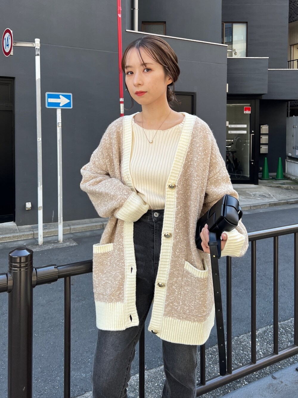 ベージュ系のカーディガン/ボレロ、ホワイト系のニット/セーター、ブラック系のデニムパンツを着用したレディースの秋コーディネートの3枚目の写真