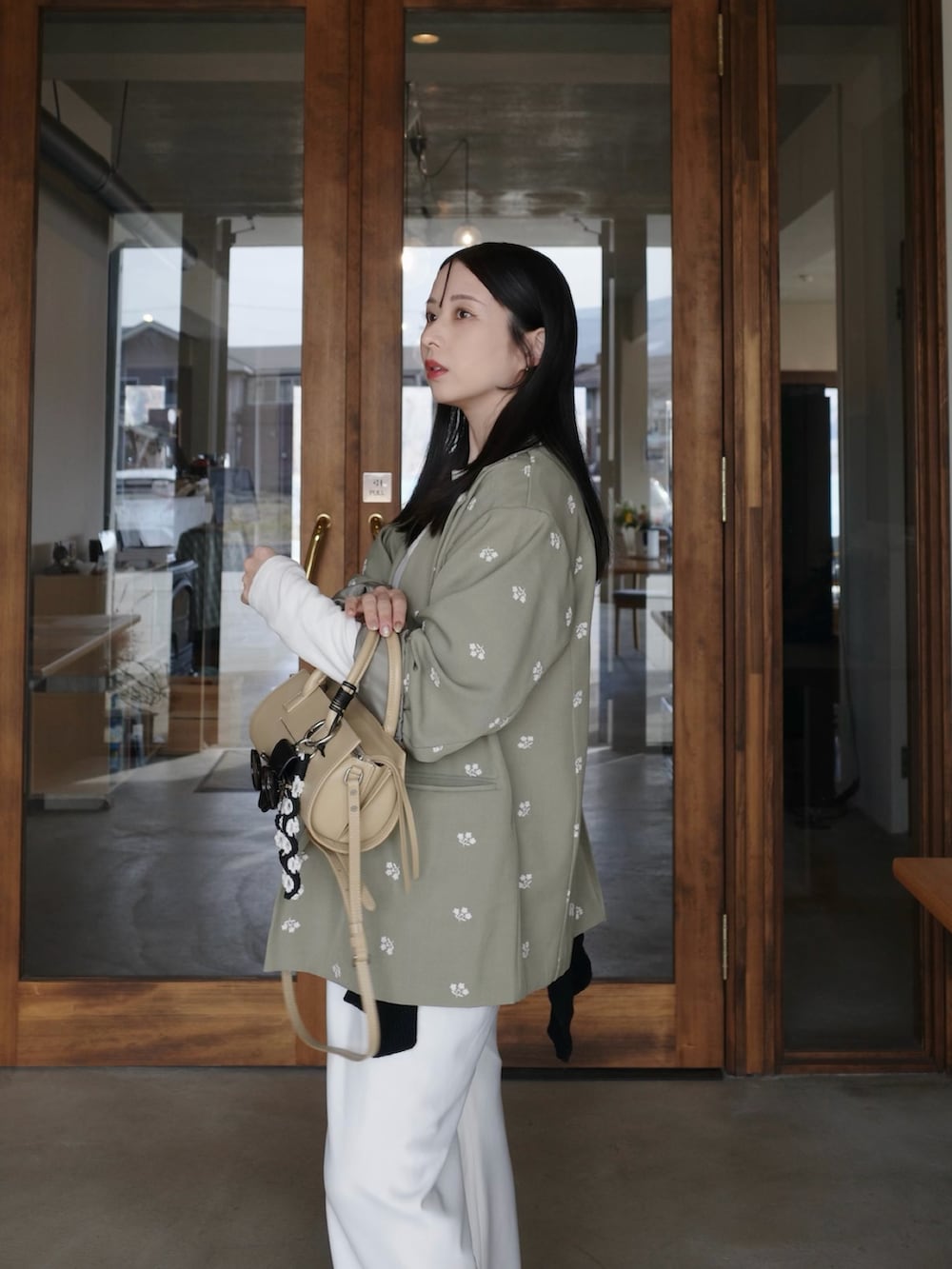 グリーン系のテーラードジャケット、ホワイト系のその他パンツ、ベージュ系のバッグを着用したレディースの春コーディネートの5枚目の写真