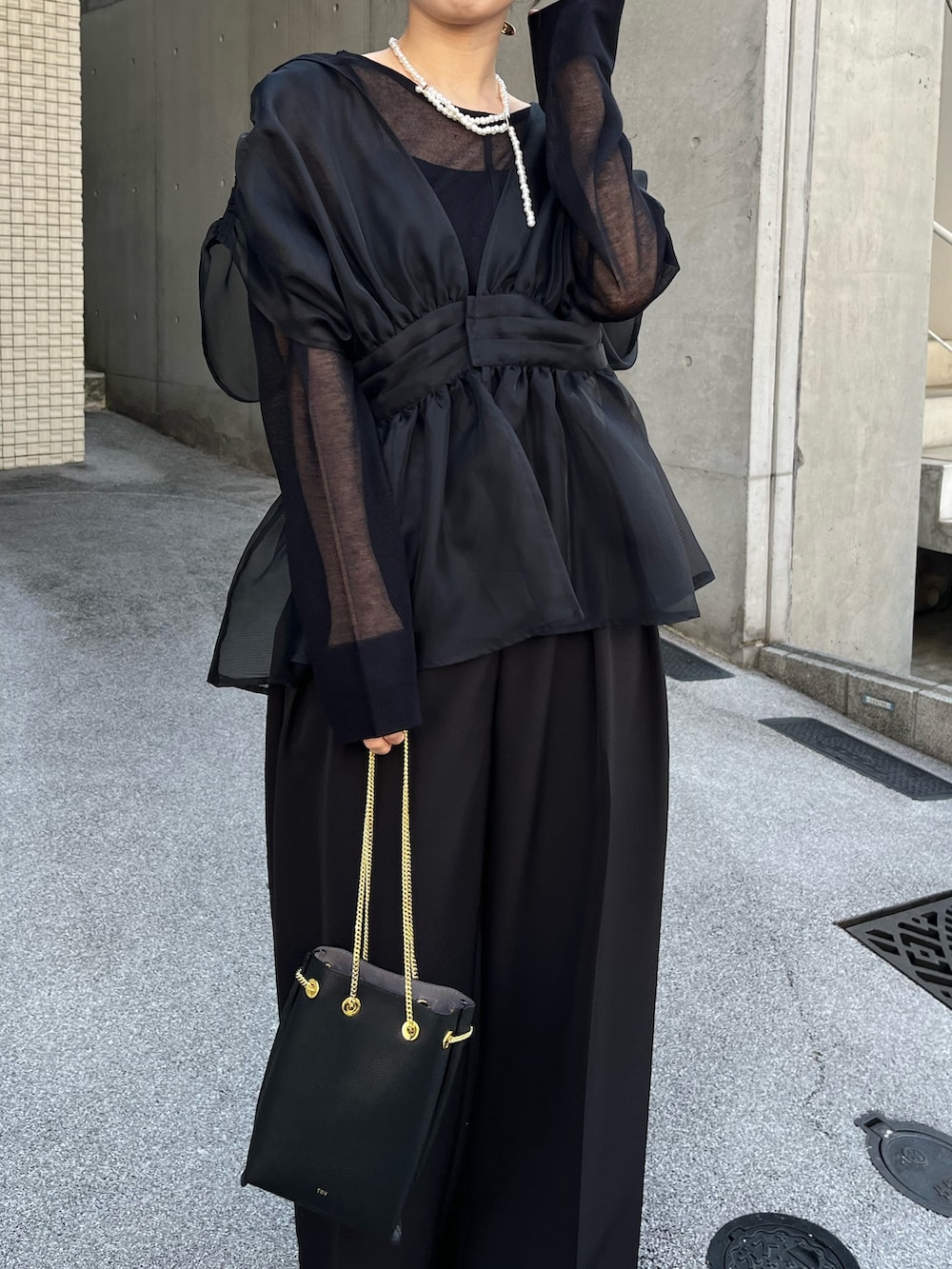 ブラック系のニット/セーター、ブラック系のシャツ/ブラウス、ブラック系のショルダーバッグを着用したレディースの冬コーディネートの3枚目の写真