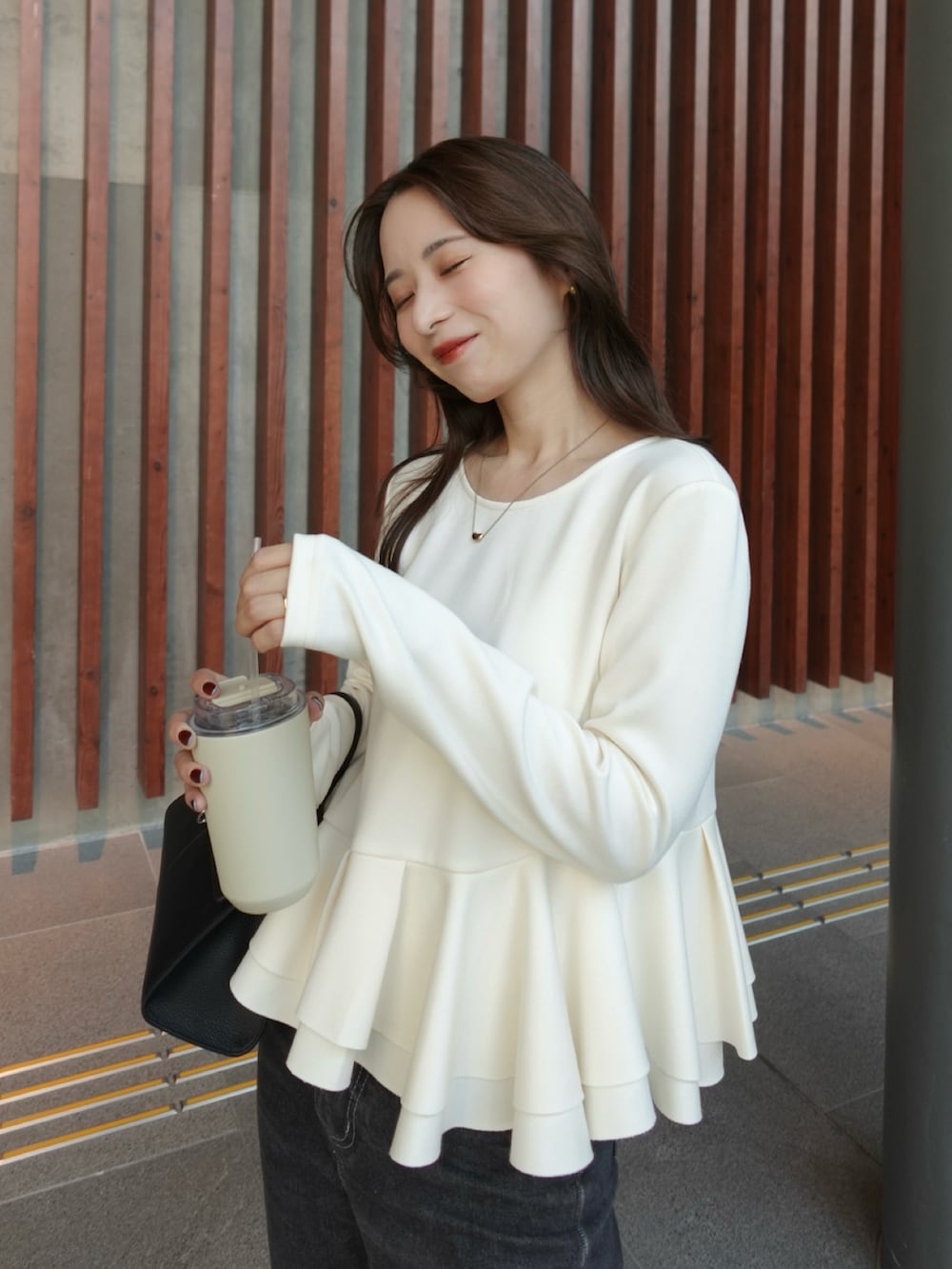 ホワイト系のTシャツ/カットソー、ブラック系のデニムパンツ、ブラック系のバレエシューズを着用したレディースの秋コーディネートの2枚目の写真