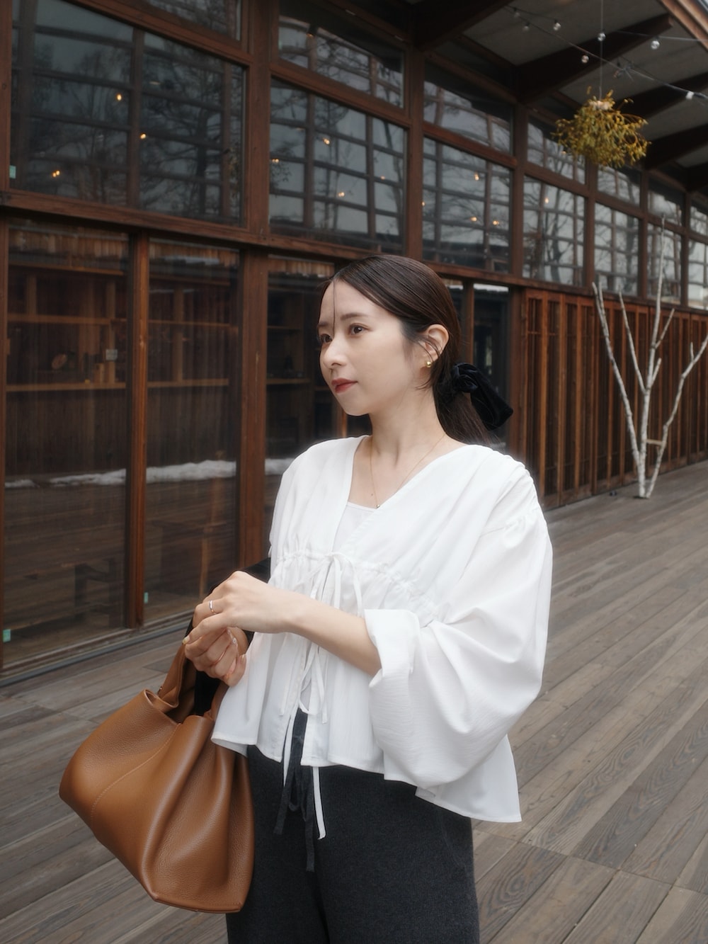 ホワイト系のシャツ/ブラウス、ブラウン系のバッグ、グレー系のパンツを着用したレディースの春コーディネートの3枚目の写真