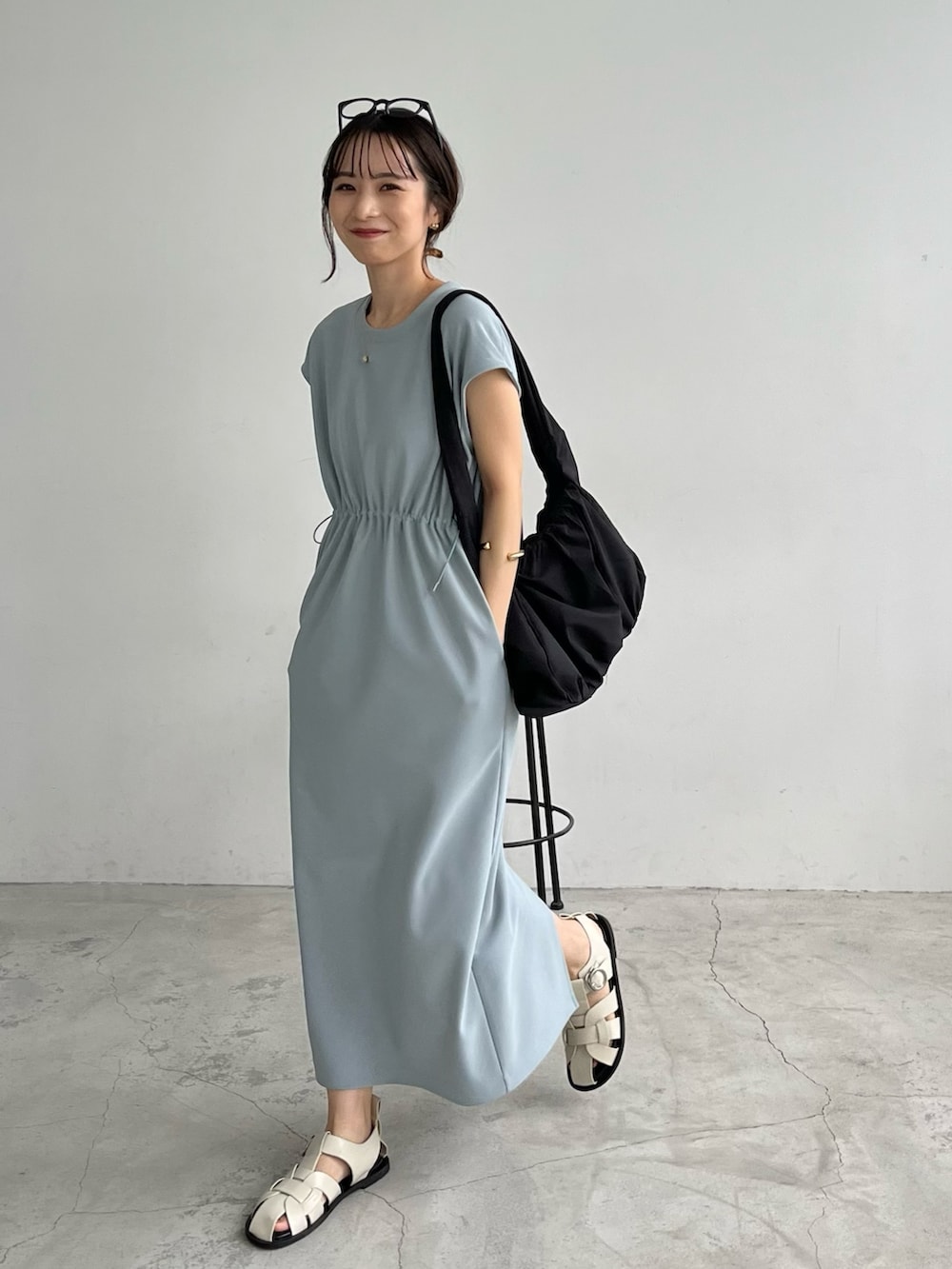 ブルー系のワンピース/ドレス、ブラック系のショルダーバッグ、ホワイト系のサンダルを着用したレディースの春コーディネートの5枚目の写真